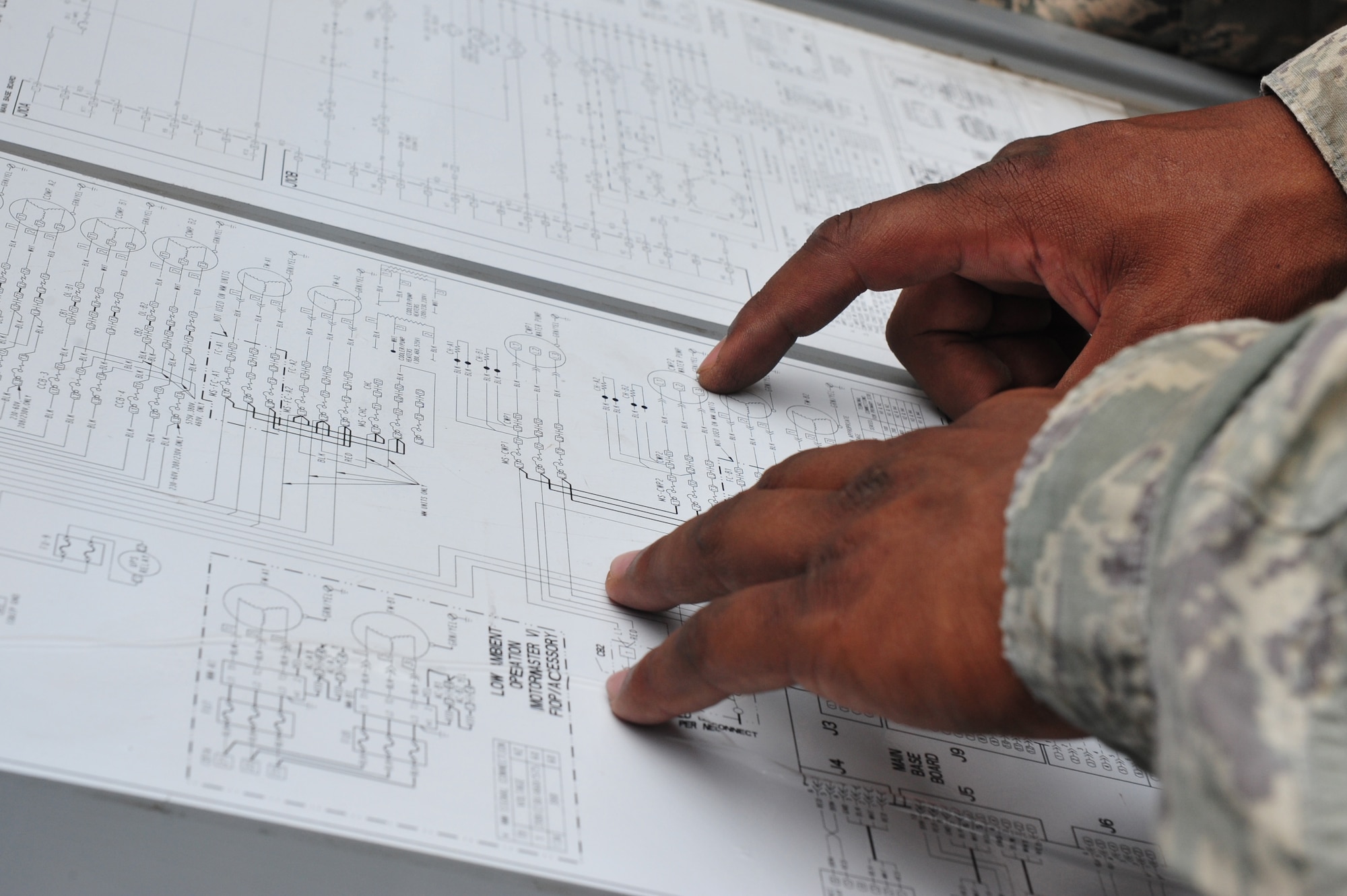 Staff Sgt. Chaddrick Webb, 8th Civil Engineer Squadron Heating, Ventilation, Air Conditioning and Refrigeration shop craftsman, deciphers an Aquasnap low voltage control schematic while responding to a work order at Kunsan Air Base, Republic of Korea, July 23, 2014. The schematic provides details on the sequence of operations for the air handler unit it is attached to, which Webb used to determine why a particular circuit was not running. (U.S. Air Force photo by 1st Lt. Earon Brown/Released)