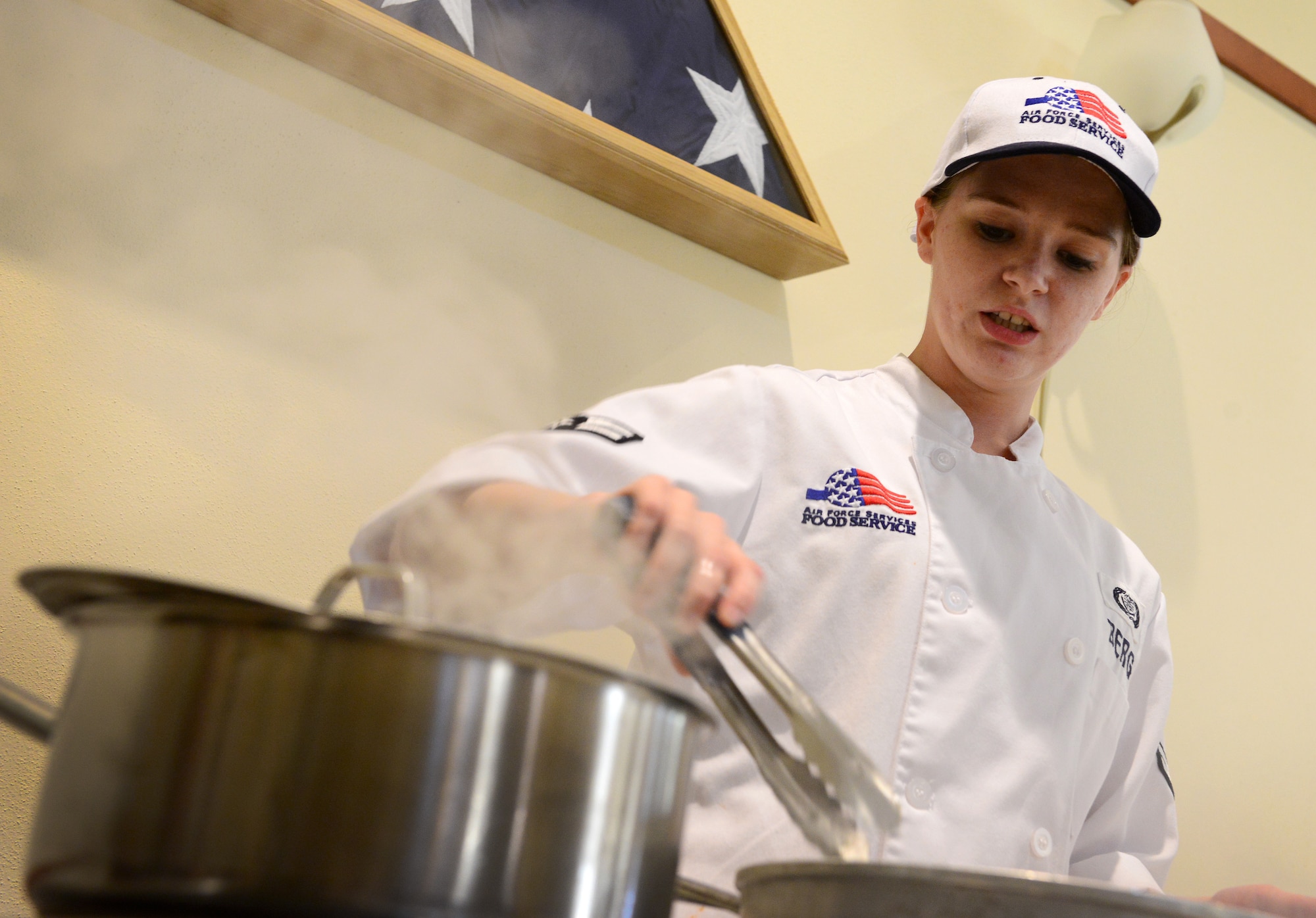 Airman 1st Class Angela Berg, 31st Force Support Squadron food services journeyman, cooks chicken during a cooking class she hosted, July 24, 2014, at Aviano Air Base, Italy. Berg hosted the event to teach Aviano Airmen living in the dormitories, how to prepare a meal with the resources available to them. (U.S. Air Force photo/Senior Airman Matthew Lotz)