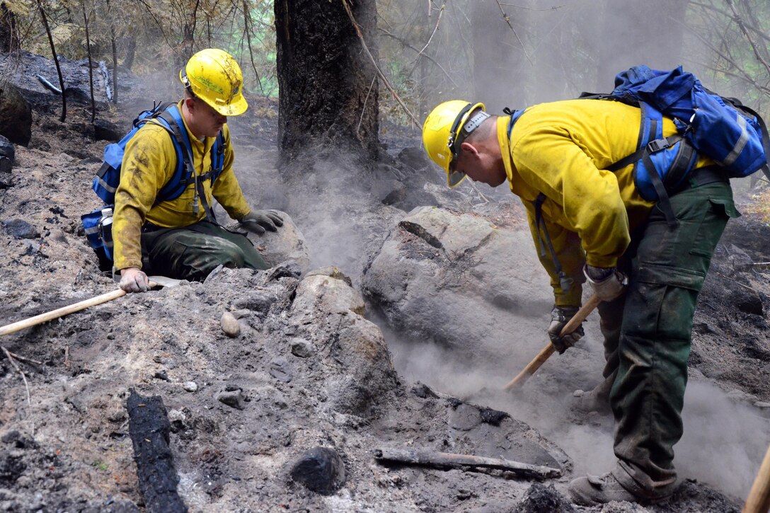Soldiers clear an area of smoldering embers that could potentially reignite fires as they assist state agencies during the Chiwaukum Complex wildfires near Leavenworth, Wash., July 23, 2014.