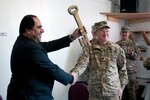 Panjshir Provincial Governor Keramuddin Karim triumphantly raises a key of the city given to him by U.S. Army Lt. Col. Daniel Gajewski, Chicago native and 321st Civil Affairs Brigade, Provincial Development Support Team commander, during a transfer of authority ceremony at Forward Operating Base Lion Dec. 28. The ceremony marked the official handover from U.S. forces to Afghan control.