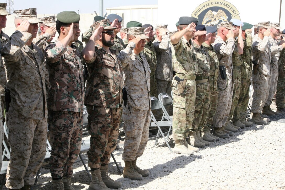 Key coalition partners with International Security Assistance Force salute in formation during a flag-lowering ceremony aboard Camp Leatherneck, Helmand province, Afghanistan, July 23, 2014. The ceremony marked the end of mission for the Kingdom of Jordan's army serving with Regional Command (Southwest).