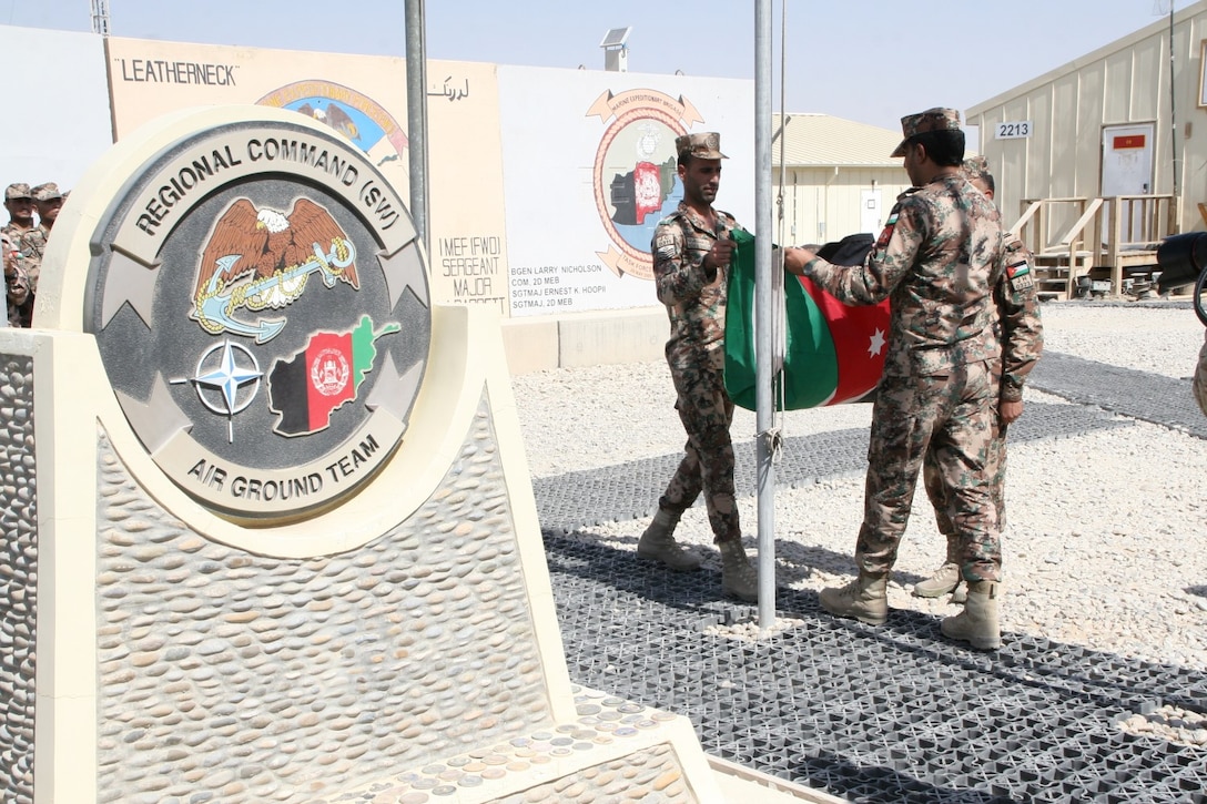 Soldiers with the Kingdom of Jordan fold their flag during a ceremony aboard Camp Leatherneck, Helmand province, Afghanistan, July 23, 2014. The ceremony marked the end of mission for the Jordanian army serving with Regional Command (Southwest).