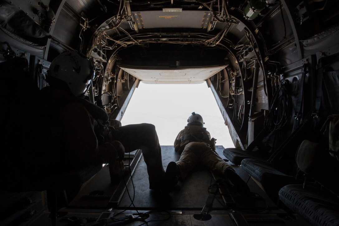 Crew chiefs with Marine Medium Tiltrotor Squadron (VMM) 166 keep watch outside of an MV-22B Osprey during a training flight from Marine Corps Air Station Miramar, Calif., July 24. The flight included confined-area landing and tactical-formations. 