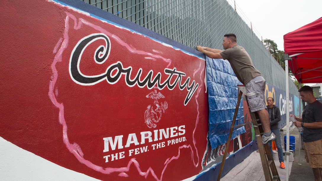 Seattle, Wa (July 24, 2014)-- Staff Sgt. Randy Kirby, production specialist, Marine Corps Recruiting Command, set up tarps prior to painting a mural for Marine Week Seattle, here, July 24. For one week, July 26-August 3, 2014, hundreds of Marines will embark on the Emerald City to meet the men and women of Seattle, Showcase equipment and aircrafts, perform band concerts, and engage in community service events.