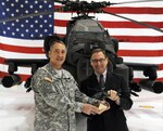 Army Maj. Gen. Stephen L. Danner, adjutant general of the Missouri National Guard, receives an Apache model from David Koopersmith, vice president of Boeing's Attack Helicopter Program, on Jan. 8, 2012.
