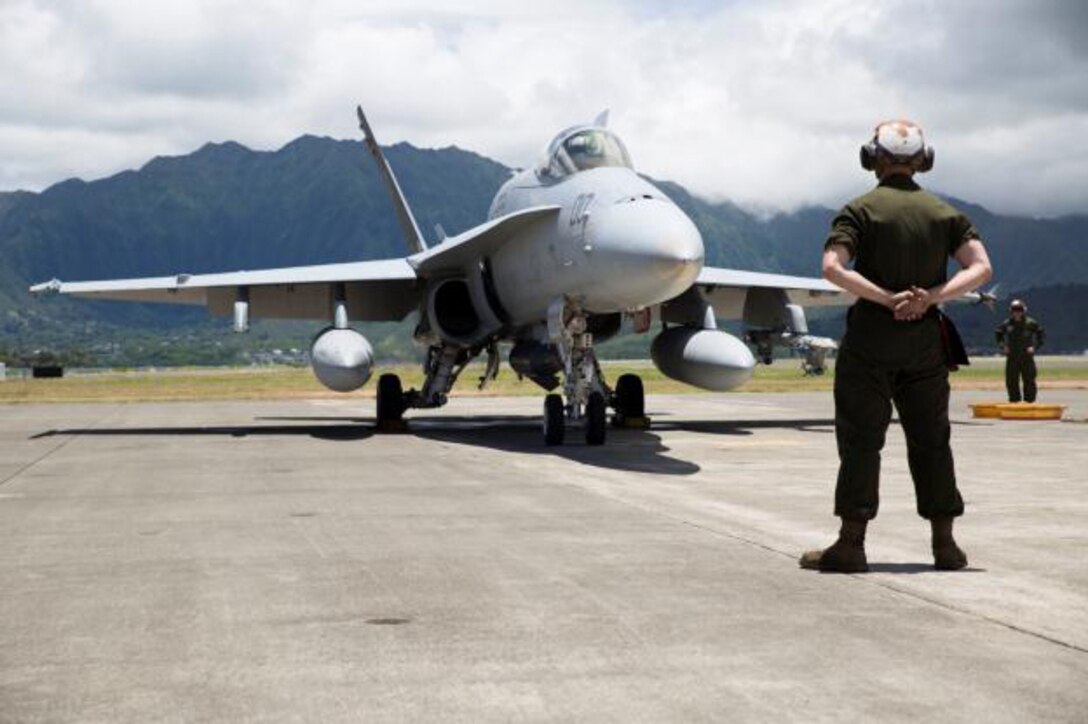 MARINE CORPS AIR STATION KANEOHE BAY - A Marine with Marine Fighter Attack Squadron 122 prepares an F/A-18C Hornet for takeoff aboard Marine Corps Air Station Kaneohe Bay, July 2, 2014. Marine Fighter Attack Squadron 122 is in Hawaii in support of Rim of the Pacific Exercise 2014, the world's largest international maritime warfare exercise. The squadron is currently a part of the Unit Deployment Program with Marine Aircraft Group 12, based out of Marine Corps Air Station Iwakuni, Japan. (U.S. Marine Corps photo by Lance Cpl. Alissa Schuning)