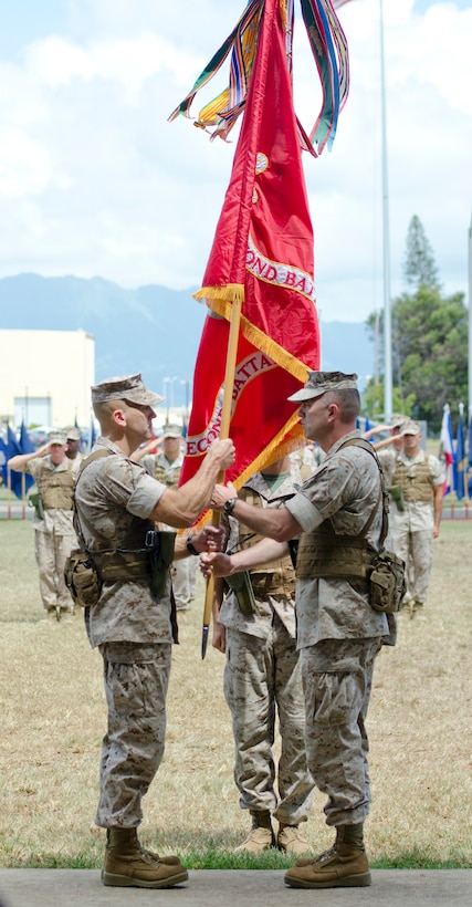 MARINE CORPS BASE HAWAII - Lt. Col. Brian P. Coyne (left), incoming commanding officer, 2nd Battalion, 3rd Marine Regiment, accepts the unit colors from Lt. Col. James B. Conway, outgoing commanding officer, during the change of command ceremony at Dewey Square, July 18, 2014. (U.S. Marine Corps photo by Kristen Wong)