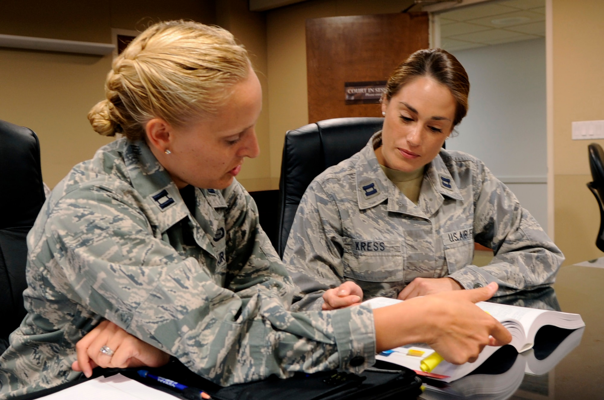 Capt. Laura Buchholtz, 30th Space Wing chief of military justice, and Capt. Sarah Kress, Area Defense Counsel, go over courtroom procedures, July 25, 2014, Vandenberg Air Force Base, Calif. With military members being held to high standards of conduct under the Uniform Code of Military Justice, the availability of fair legal representation is an Air Force priority. (U.S. Air Force photo by Senior Airman Shane Phipps/Released)