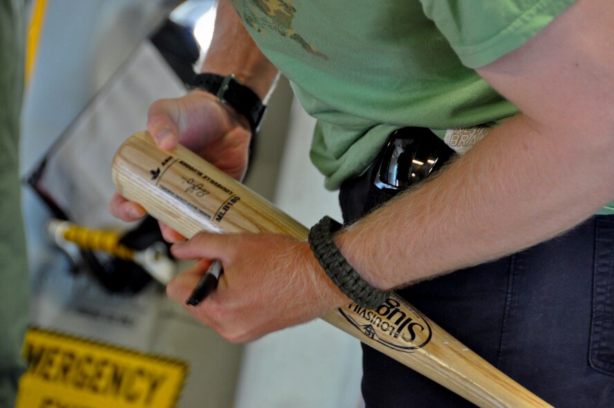 Sean Doolittle, Oakland A's pitcher, signs a baseball bat for an Airman July 21 at Travis Air Force Base. Doolittle toured Travis and signed memorabilia for fans along the way. (U.S. Air Force photo by Airman 1st Class Amber Carter)