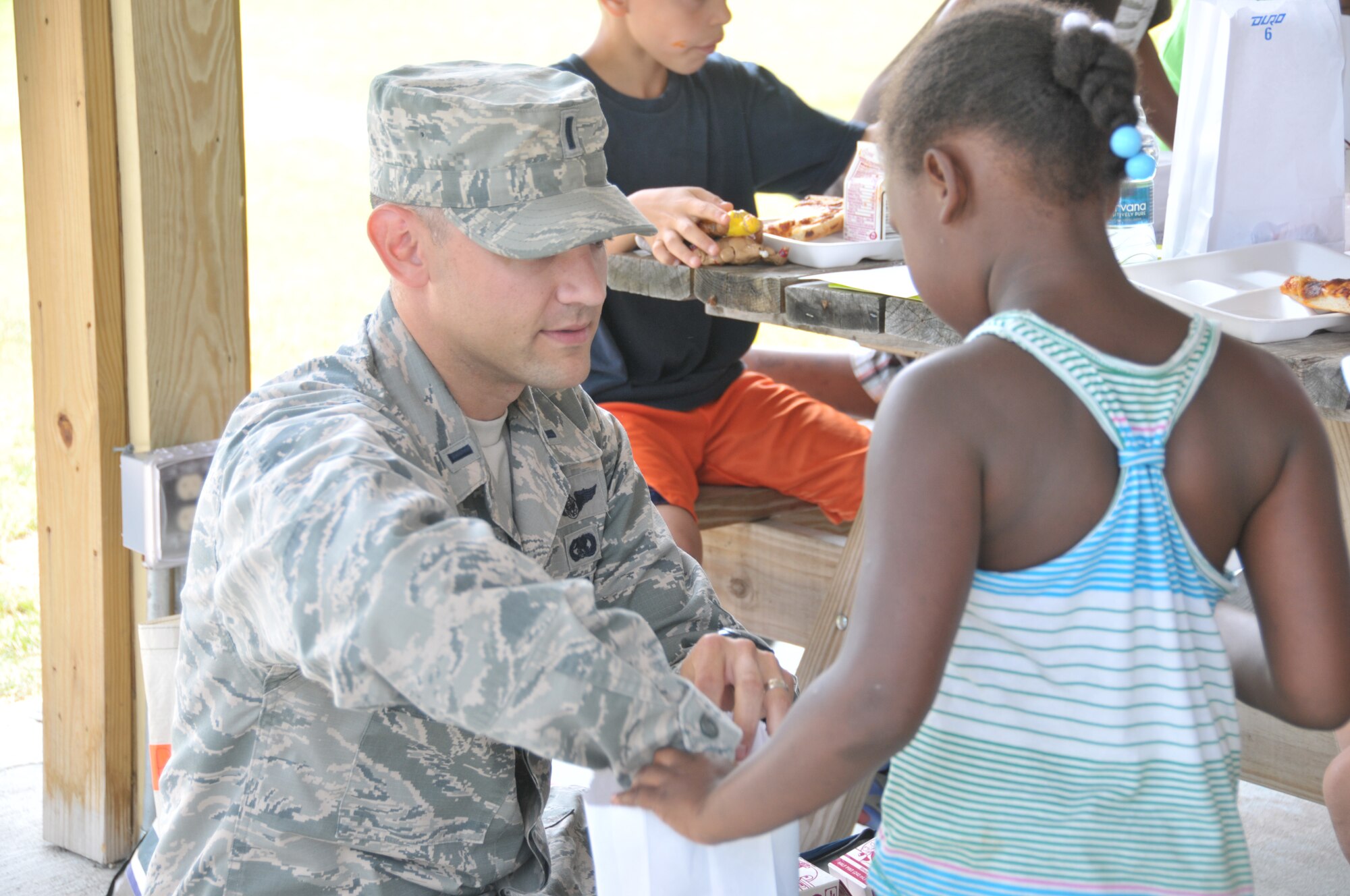 First Lt. Jared Semerad, 109th Logistics Readiness Squadron, hands out lunches to youth at Steinmetz Park in Schenectady, New York, July 25, 2014. About 30 Airmen from the 109th Airlift Wing volunteered throughout the week to help with Schenectady Inner City Ministry's Summer Lunch Program. The ministry has been providing free lunches to youth throughout Schenectady for 20 years. (U.S. Air National Guard photo by Tech. Sgt. Catharine Schmidt/Released)