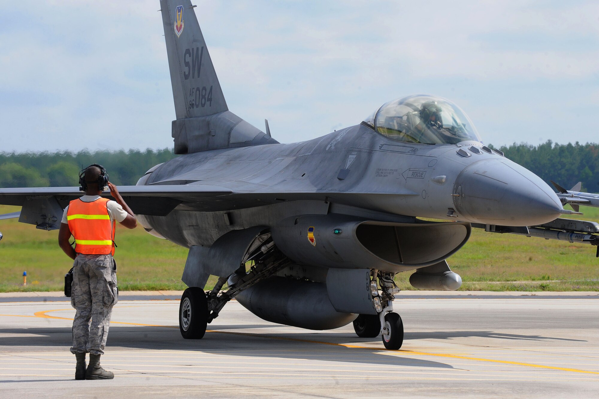 U.S. Air Force Airman 1st Class Jordan Cotton, 20th Aircraft Maintenance Squadron, 77th Aircraft Maintenance Unit tactical aircraft maintainer, salutes Maj. Justin Lewis, 55th Fighter Squadron F-16CJ Fighting Falcon pilot, before take-off at Shaw Air Force Base, S.C., July 23, 2014.Airman inspecting the aircrafts at the end of the run way before take-off to ensure it is functioning properly. (U.S. Air Force photo by Airman 1st Class Michael A. Cossaboom/Released)