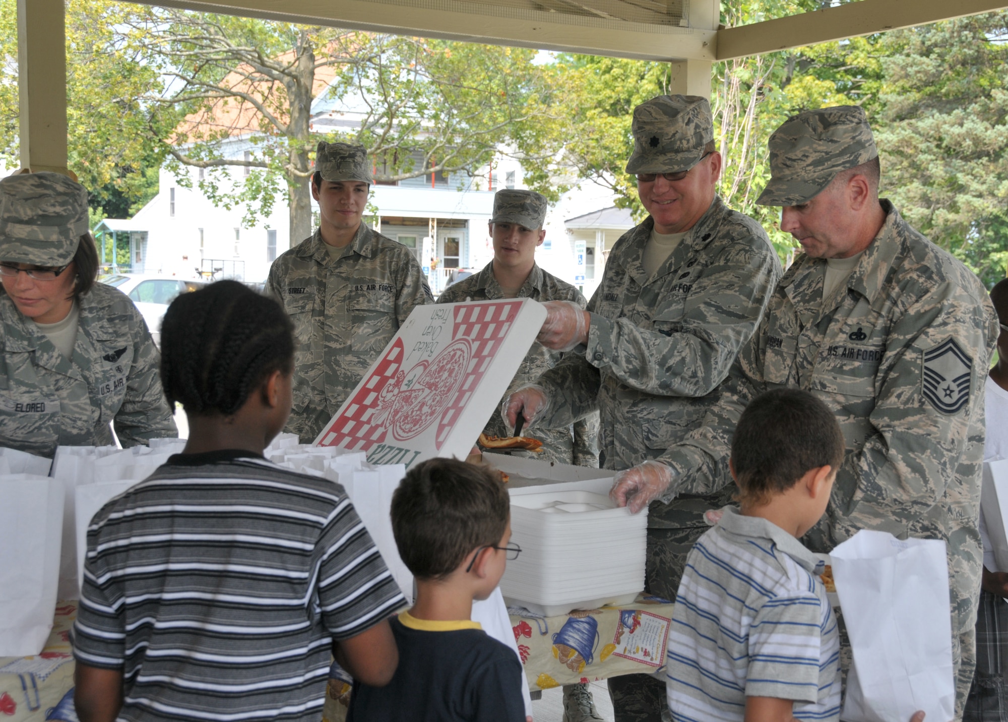 (From left) Tech. Sgt. Sara Eldred, Airman 1st Class Daniel Street, Airman 1st Class Elijah Hammond-Wood, Lt. Col. Ty Randall and Senior Master Sgt. Kevin Moughan hand out lunches to youth at Steinmetz Park in Schenectady, New York, July 25, 2014. About 30 Airmen from the 109th Airlift Wing volunteered throughout the week to help with Schenectady Inner City Ministry's Summer Lunch Program. The ministry has been providing free lunches to youth throughout Schenectady for 20 years. Eldred, Street, and Hammond-Wood are all with the 139th Aeromedical Evacuation Squadron; Randall is the 109th Civil Engineer Squadron commander; and Moughan is assigned to the 109th Maintenance Group. (U.S. Air National Guard photo by Tech. Sgt. Catharine Schmidt/Released)