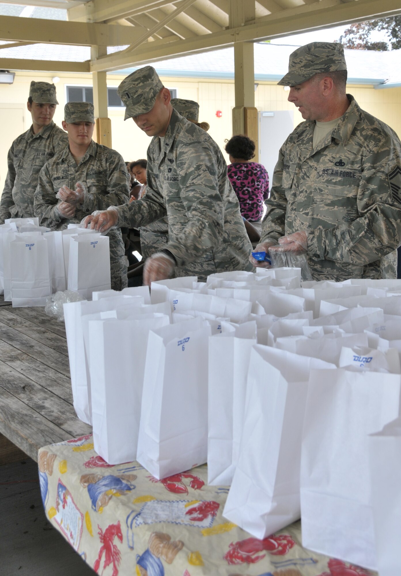 (From left) Airman 1st Class Daniel Street, Airman 1st Class Elijah Hammond-Wood, 1st Lt. Jared Semerad and Senior Master Sgt. Kevin Moughan hand out lunches to youth at Steinmetz Park in Schenectady, New York, July 25, 2014. About 30 Airmen from the 109th Airlift Wing volunteered throughout the week to help with Schenectady Inner City Ministry's Summer Lunch Program. The ministry has been providing free lunches to youth throughout Schenectady for 20 years. Street and Hammond-Wood  are with the 139th Aeromedical Evacuation Squadron; Semerad is assigned to the 109th Logistics Readiness Squadron; and Moughan is assigned to the 109th Maintenance Group. (U.S. Air National Guard photo by Tech. Sgt. Catharine Schmidt/Released)