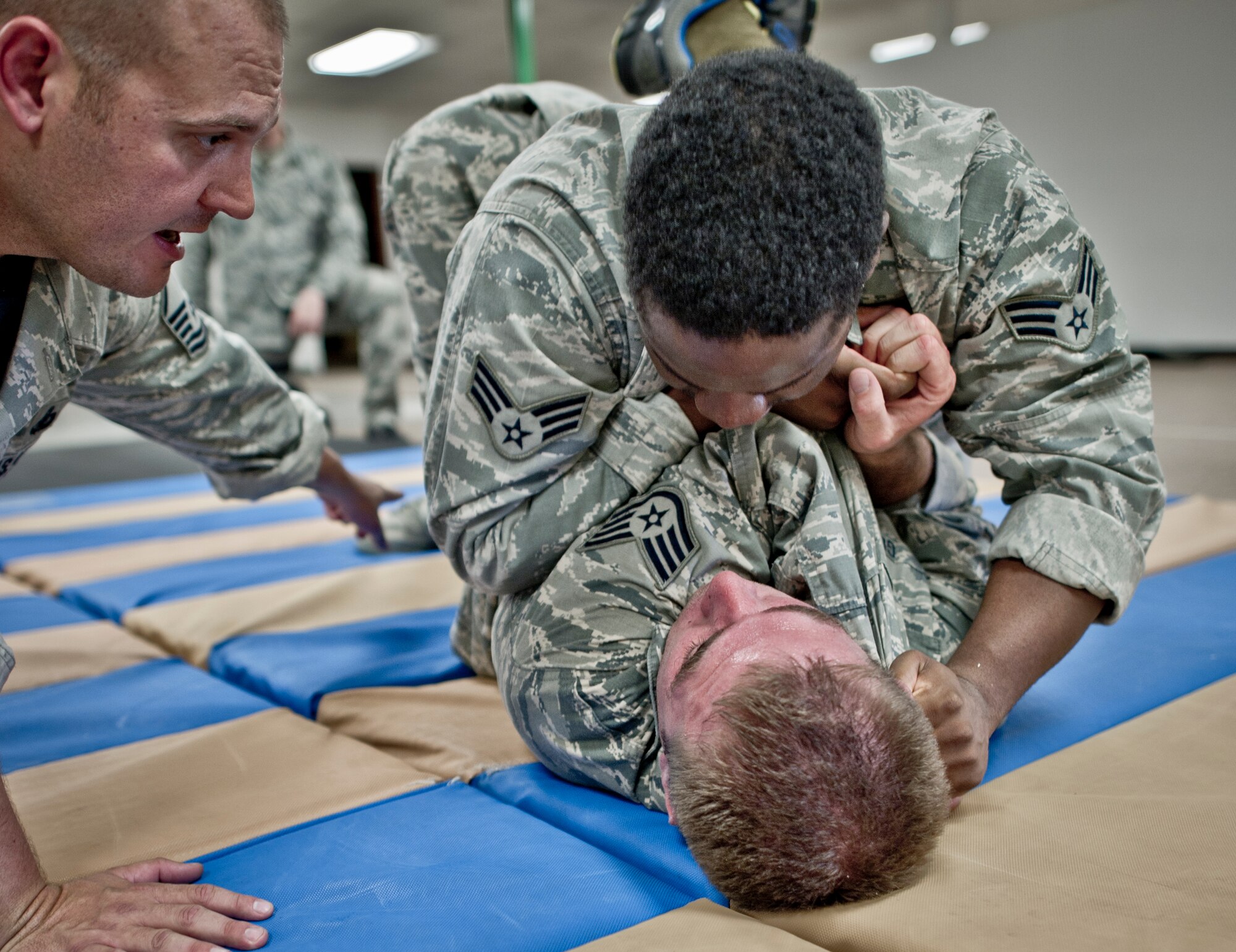 Senior Airman Julian Benjamin (top) and Staff Sgt. Justin Goad (bottom), 49th Security Forces Squadron conduct grappling drills combatives training at Holloman Air Force Base, N.M., July 18. Security Forces combatives training is designed to equip SFS personnel with the knowledge and skills to respond to potentially deadly confrontations. It's a physically demanding 20-hour training block that encompasses both standing and ground offensive, defensive and apprehension techniques. (U.S. Air Force photo by Staff Sgt Stacy Moless/Released)