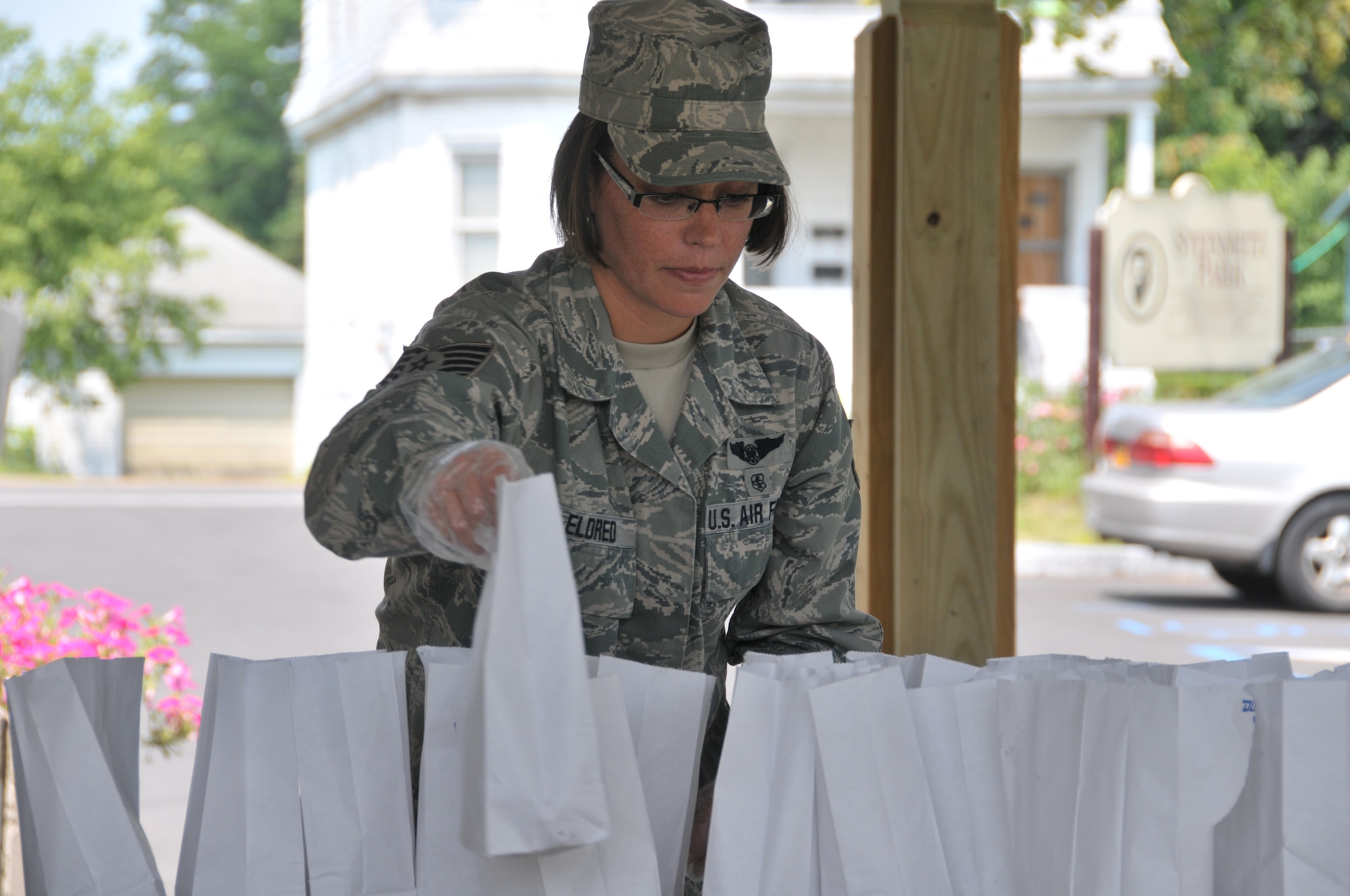 Tech. Sgt. Sara Eldred, 139th Aeromedical Evacuation Squadron, hands out lunches to youth at Steinmetz Park in Schenectady, New York, July 25, 2014. About 30 Airmen from the 109th Airlift Wing volunteered throughout the week to help with Schenectady Inner City Ministry's Summer Lunch Program. The ministry has been providing free lunches to youth throughout Schenectady for 20 years. (U.S. Air National Guard photo by Tech. Sgt. Catharine Schmidt/Released)