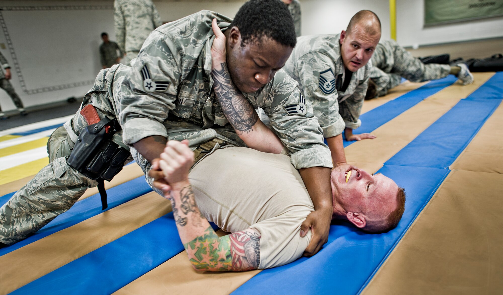 Senior Airman Julian Benjamin (top) and Master Sgt. Kurtis Musson (bottom), 49th Security Forces Squadron conduct grappling drills combatives training at Holloman Air Force Base, N.M., July 18. Security Forces combatives training is designed to equip SFS personnel with the knowledge and skills to respond to potentially deadly confrontations. It's a physically demanding 20-hour training block that encompasses both standing and ground offensive, defensive and apprehension techniques. (U.S. Air Force photo by Staff Sgt Stacy Moless/Released)