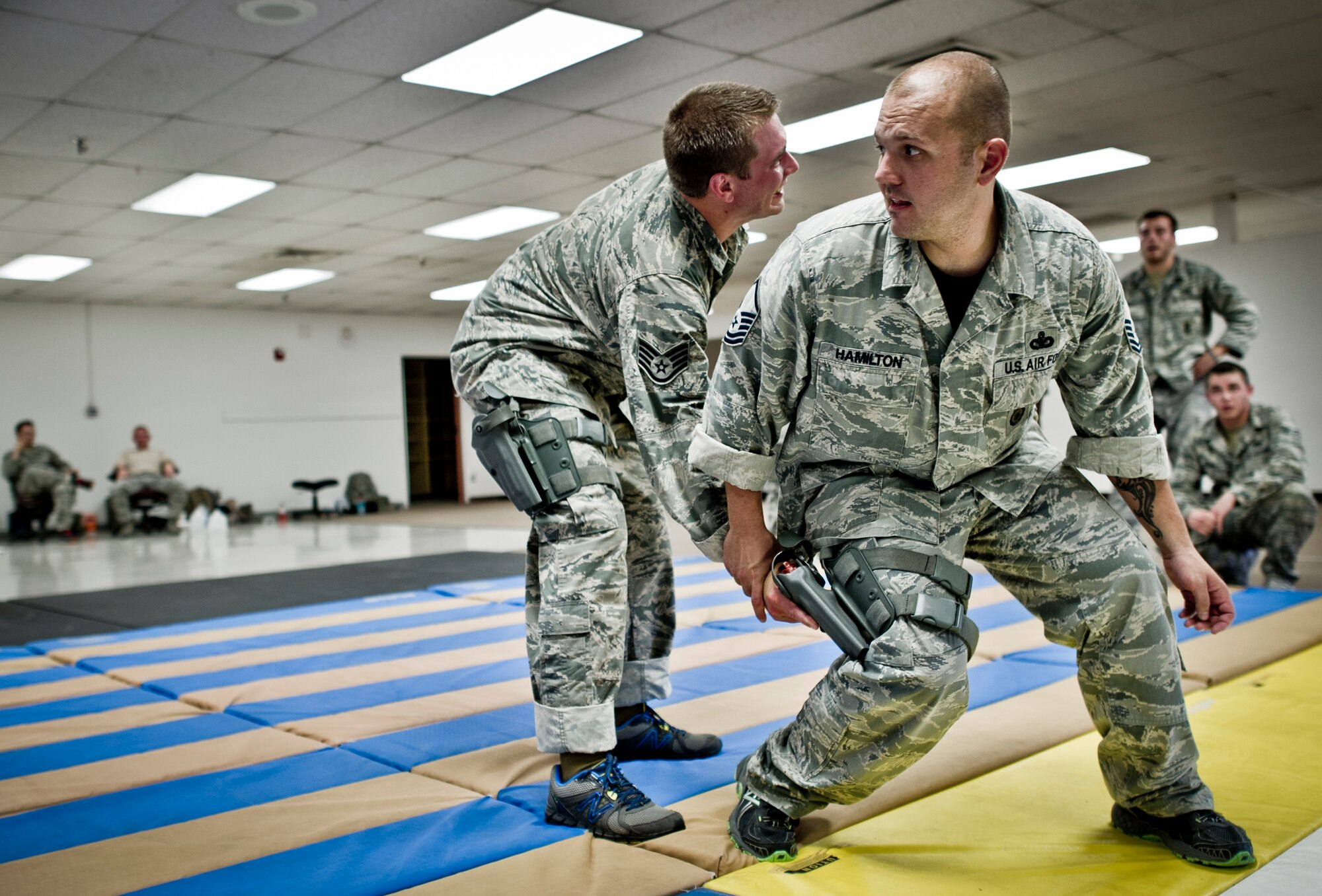 Staff Sgt. Justin Goad (left) and Master Sgt. Joseph Hamilton (right), 49th Security Forces Squadron demonstrates weapon retention combatives training at Holloman Air Force Base, N.M., July 18. Security Forces combatives training is designed to equip SFS personnel with the knowledge and skills to respond to potentially deadly confrontations. It's a physically demanding 20-hour training block that encompasses both standing and ground offensive, defensive and apprehension techniques. (U.S. Air Force photo by Staff Sgt Stacy Moless/Released)