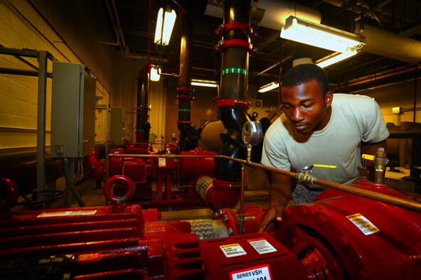 U.S. Air Force Senior Airman Jarell Rose, 20th Civil Engineer Squadron heating, ventilation, air conditioning and refrigerating journeyman, inspects a water pump motor at Shaw Air Force Base, S.C., July 23, 2014. Rose checked each of the three motors that pump condensed water back into the chiller. (U.S. Air Force photo by Airman 1st Class Jensen Stidham/Released)