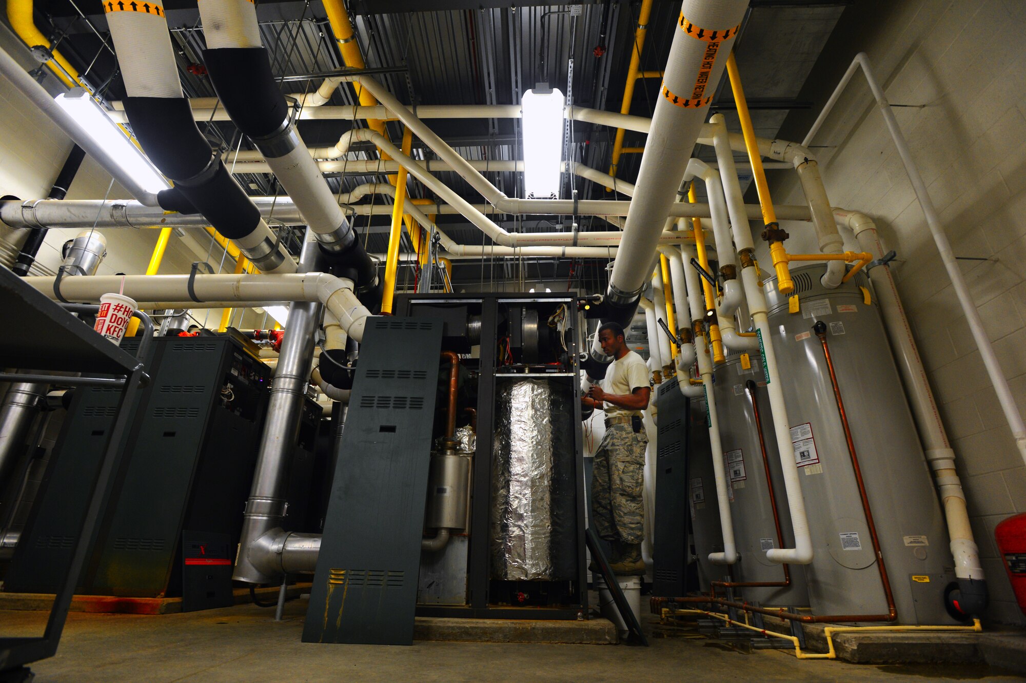 U.S. Air Force Senior Airman Jarell Rose, 20th Civil Engineer Squadron heating, ventilation, air conditioning and refrigerating journeyman, performs maintenance on a boiler at Shaw Air Force Base, S.C., July 23, 2014. Rose attempted to fix two of the six boilers that provide hot water to Patton Hall. (U.S. Air Force photo by Airman 1st Class Jensen Stidham/Released) 