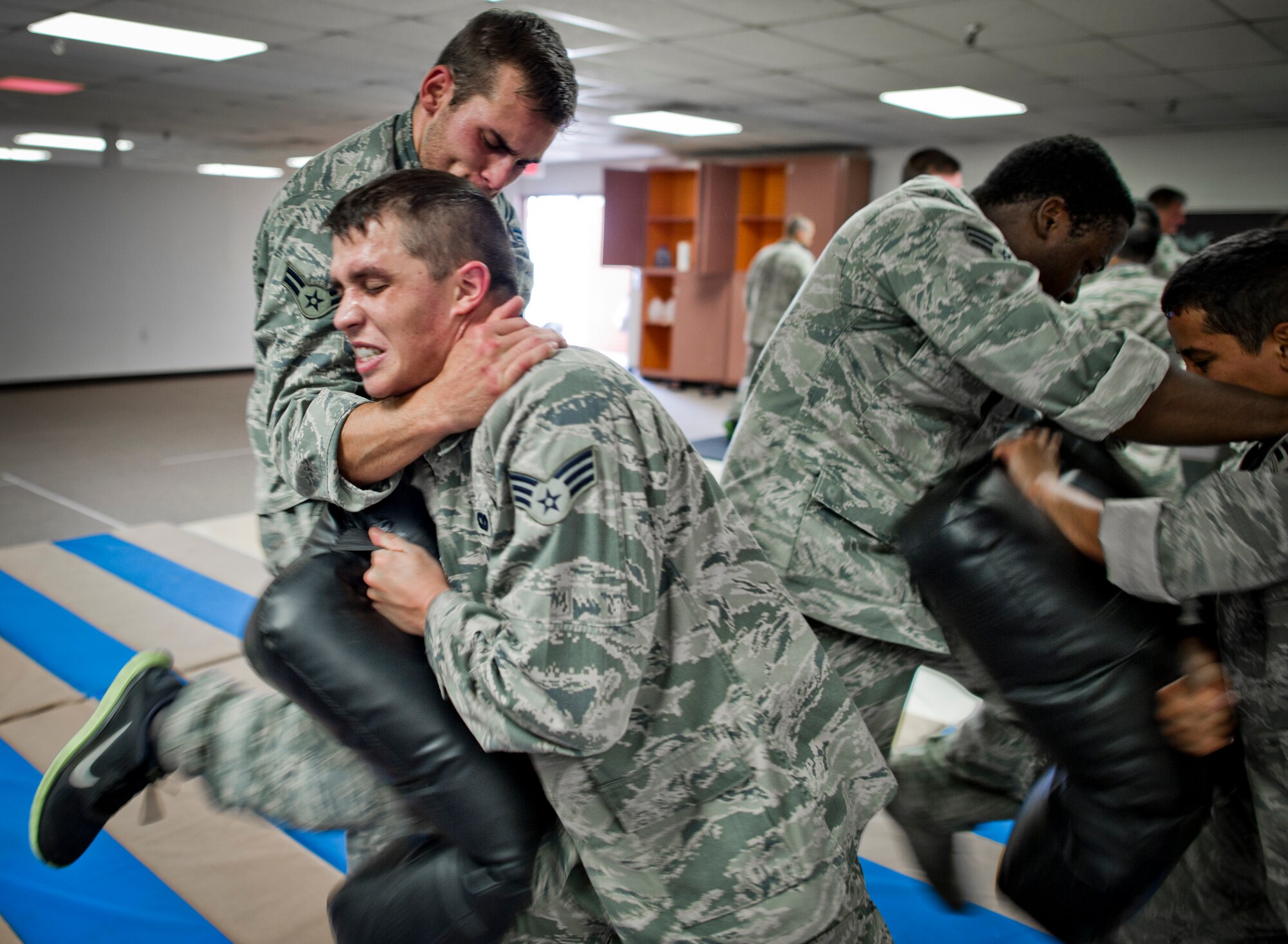49th Security Forces Squadron members conduct knee strikes combatives training at Holloman Air Force Base, N.M., July 18. Security Forces combatives training is designed to equip SFS personnel with the knowledge and skills to respond to potentially deadly confrontations. It's a physically demanding 20-hour training block that encompasses both standing and ground offensive, defensive and apprehension techniques. (U.S. Air Force photo by Staff Sgt Stacy Moless/Released)
