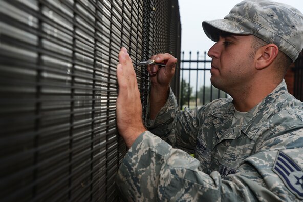 U.S. Air Force Staff Sgt. Nicholas Bennett, 20th Civil Engineer Squadron heating, ventilation, air conditioning and refrigerating craftsman, straightens out metal fins on a condenser coil at Shaw Air Force Base, S.C., July 22, 2014. The 140 ton air conditioning unit, made up of several separate components, supplies the Shaw Fitness Center with cool air at approximately 55 degrees. (U.S. Air Force photo by Airman 1st Class Jensen Stidham/Released)
