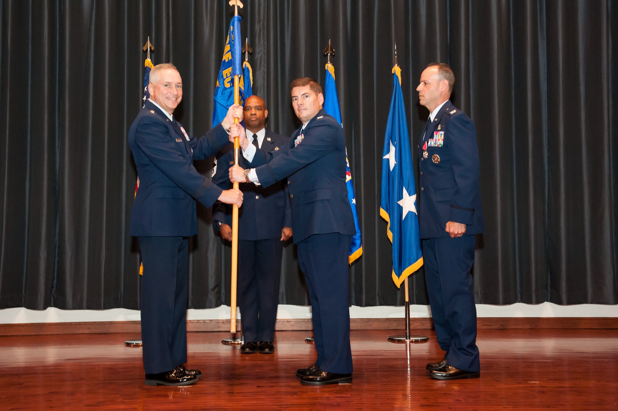 Col. Jay Junkins receives the Expeditionary Operations School guidon from Maj. Gen. Frederick H. Martin, commander of the U.S. Air Force Expeditionary Center during the change of command ceremony at Joint Base McGuire-Dix-Lakehurst, N.J., July 25, 2014. The EOS is responsible for developing and conducting Combat Airman Skills Training, mobility intelligence education, and facilitating the Air Force exercise Eagle Flag which focuses on the integration of all Expeditionary Combat Support skills. (U.S. Air Force photo by Russell Meseroll)