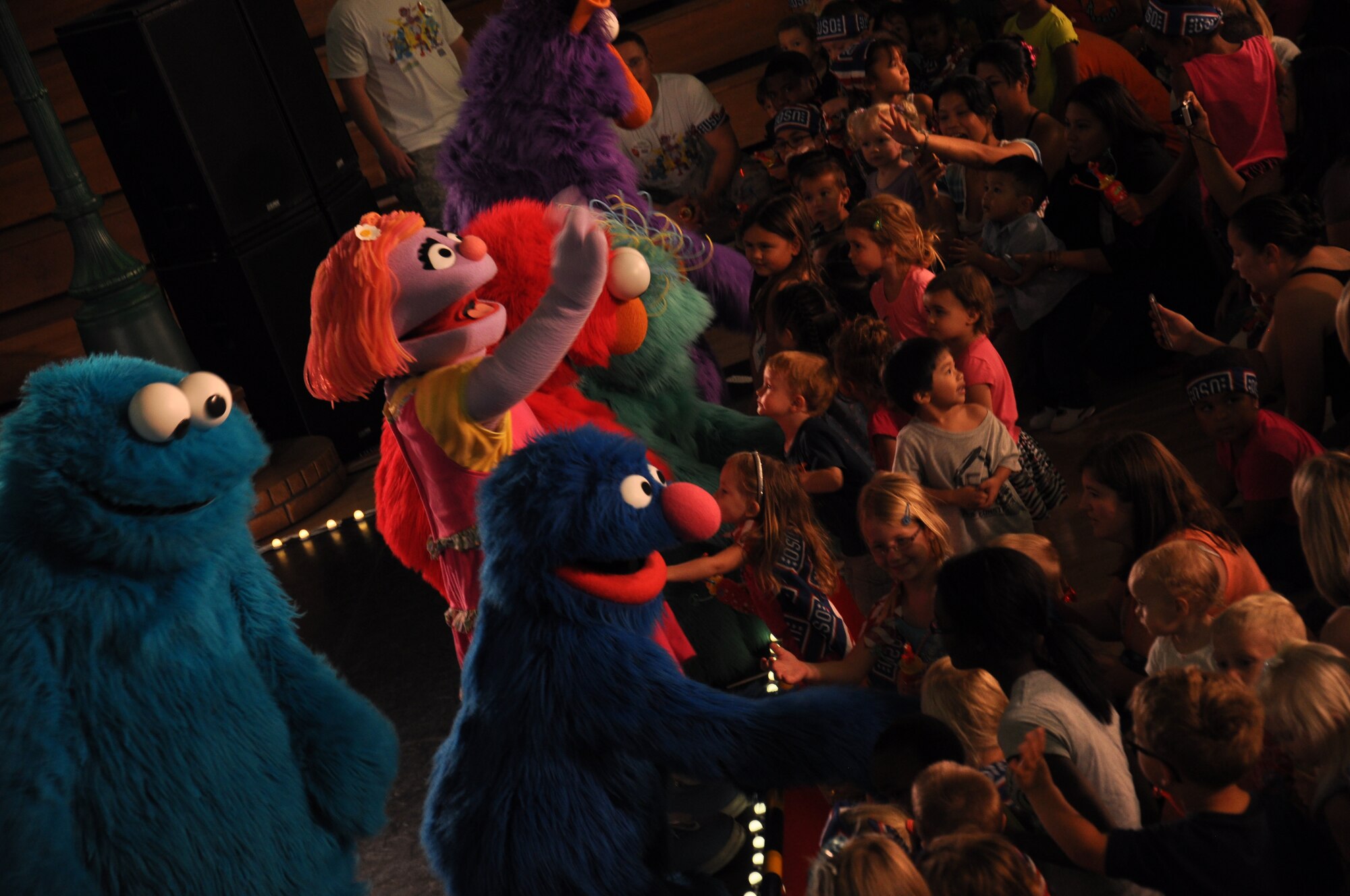 The Sesame Street character Katie waves to children as the rest of her friends interact with Golden Cubs Tuesday during the Sesame Street USO Experience for Military Families at the Travis Air Force Base Fitness Center. There were approximately 1,600 Golden Bears and their Cubs who attended the shows Tuesday and Wednesday.(U.S. Air Force photo/Staff Sgt. Christopher Carranza)