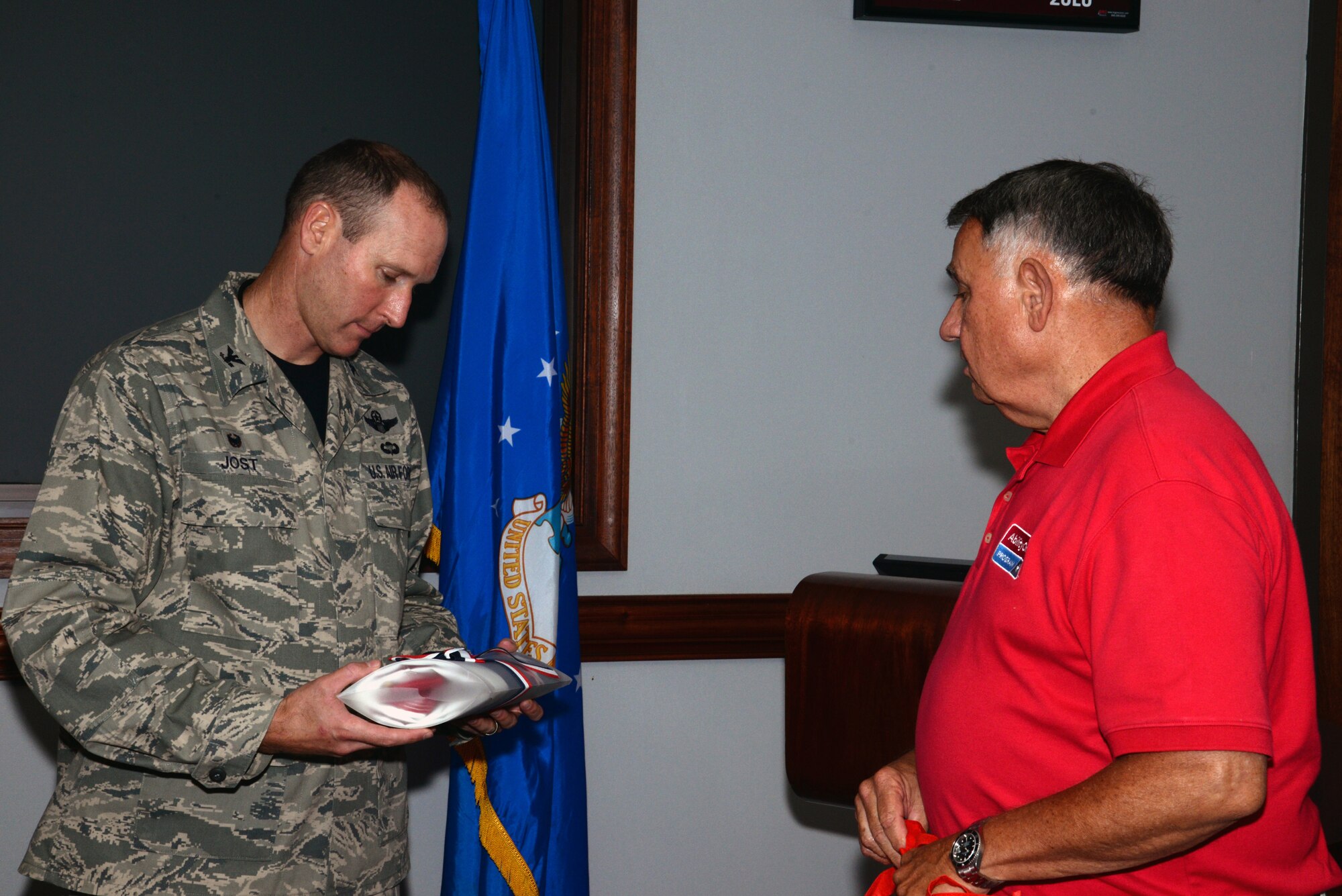 U.S. Air Force Col. Stephen Jost, 20th Fighter Wing commander, receives an American flag from Dave Theimer, Source America assistant vice president of marketing before the Ability One employee appreciation picnic at Shaw Air Force Base, S.C., July 25, 2014. SourceAmerica is the company that runs the Ability One program. (U.S. Air Force photo by Airman 1st Class Jonathan Bass/Released)