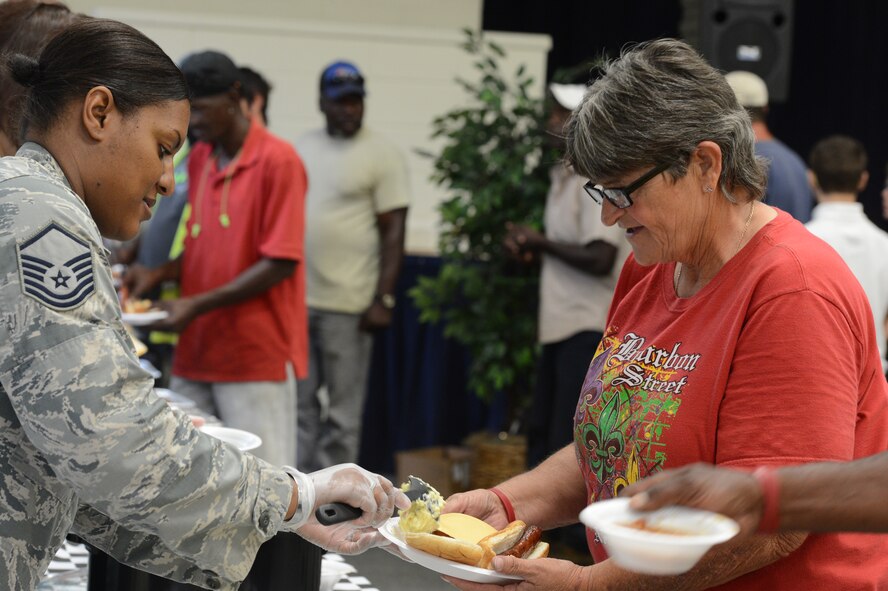 U.S. Air Force Master Sgt. Tameka Taylor, 20th Contracting Squadron superintendent, serves potato salad to an attendee of the Ability One employee appreciation picnic at Shaw Air Force Base, S.C., July 25, 2014. The 20th CONS hosted the picnic, which recognizes all the hard work of the Ability One employees. (U.S. Air Force photo by Airman 1st Class Jonathan Bass/Released)