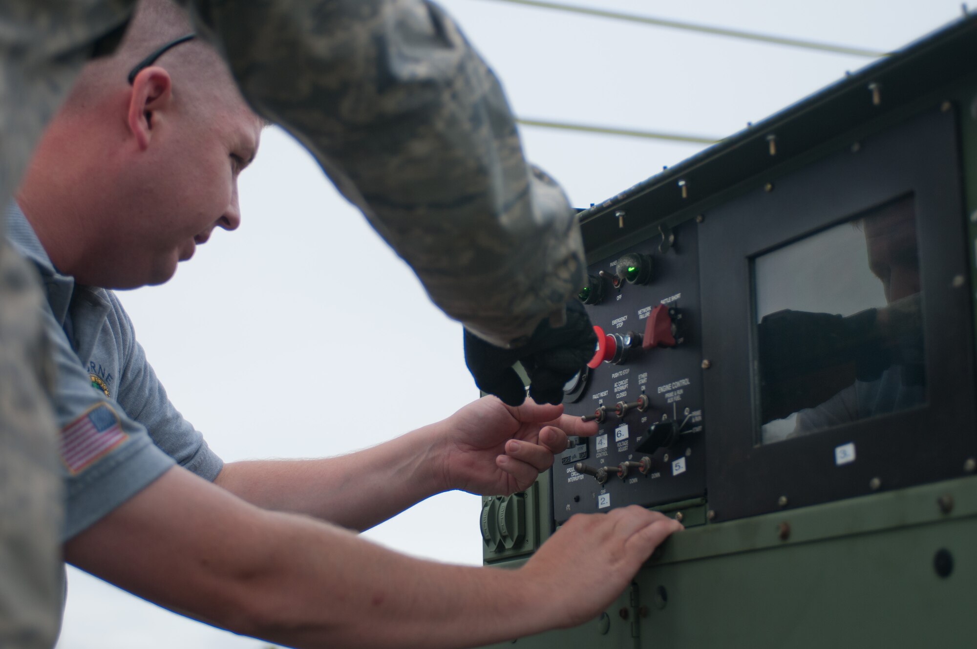Senior Airman Joseph Smolinsky demonstrates to Lt. Greg Edgcomb, of the Bourne Fire Department, how to operate a power-generation unit July 24, 2014 on Mashnee Rd. in Bourne, Mass. The power-unit is part of an emergency medical station that will be manned by Bourne Fire Department members during the Pan-Mass Challenge, an annual bike-a-thon that supports the Dana-Farber Cancer Institute.(National Guard photo by Master Sgt. Aaron Smith/Released)