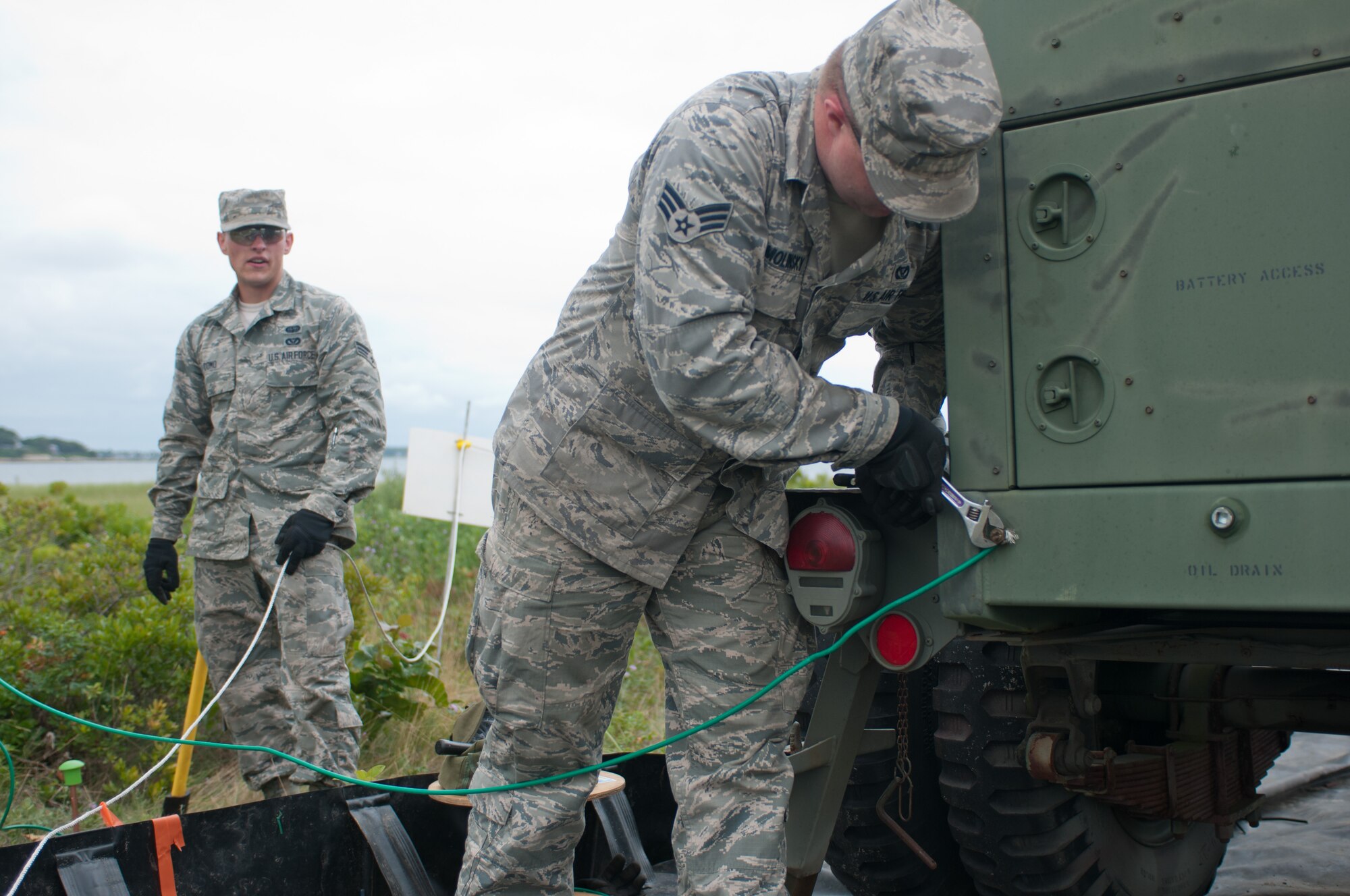 Senior Airman Joseph Smolinsky tightens a grounding wire on a power-generation unit July 24, 2014 on Mashnee Rd. in Bourne, Mass. The power-unit is part of an emergency medical station that will be manned by Bourne Fire Department members during the Pan-Mass Challenge, an annual bike-a-thon that supports the Dana-Farber Cancer Institute.(National Guard photo by Master Sgt. Aaron Smith/Released)