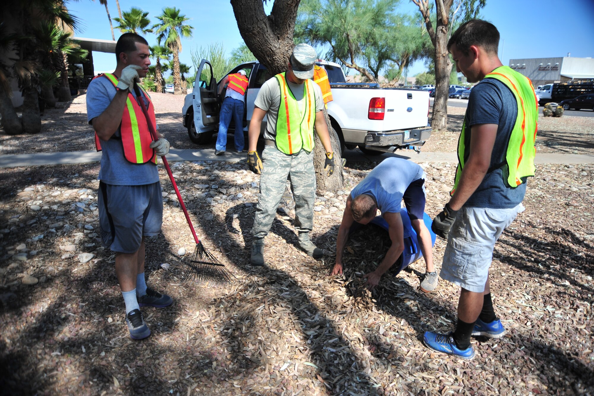 Members of the 355th Force Support Squadron clean up storm debris caused by a severe monsoon storm, at Davis-Monthan Air Force Base, Ariz., July 24, 2014.  All week, squadrons at D-M cleaned up the debris from designated sections around the base.  (U.S. Air Force Photo by Airman 1st Class Chris Massey/Released)
