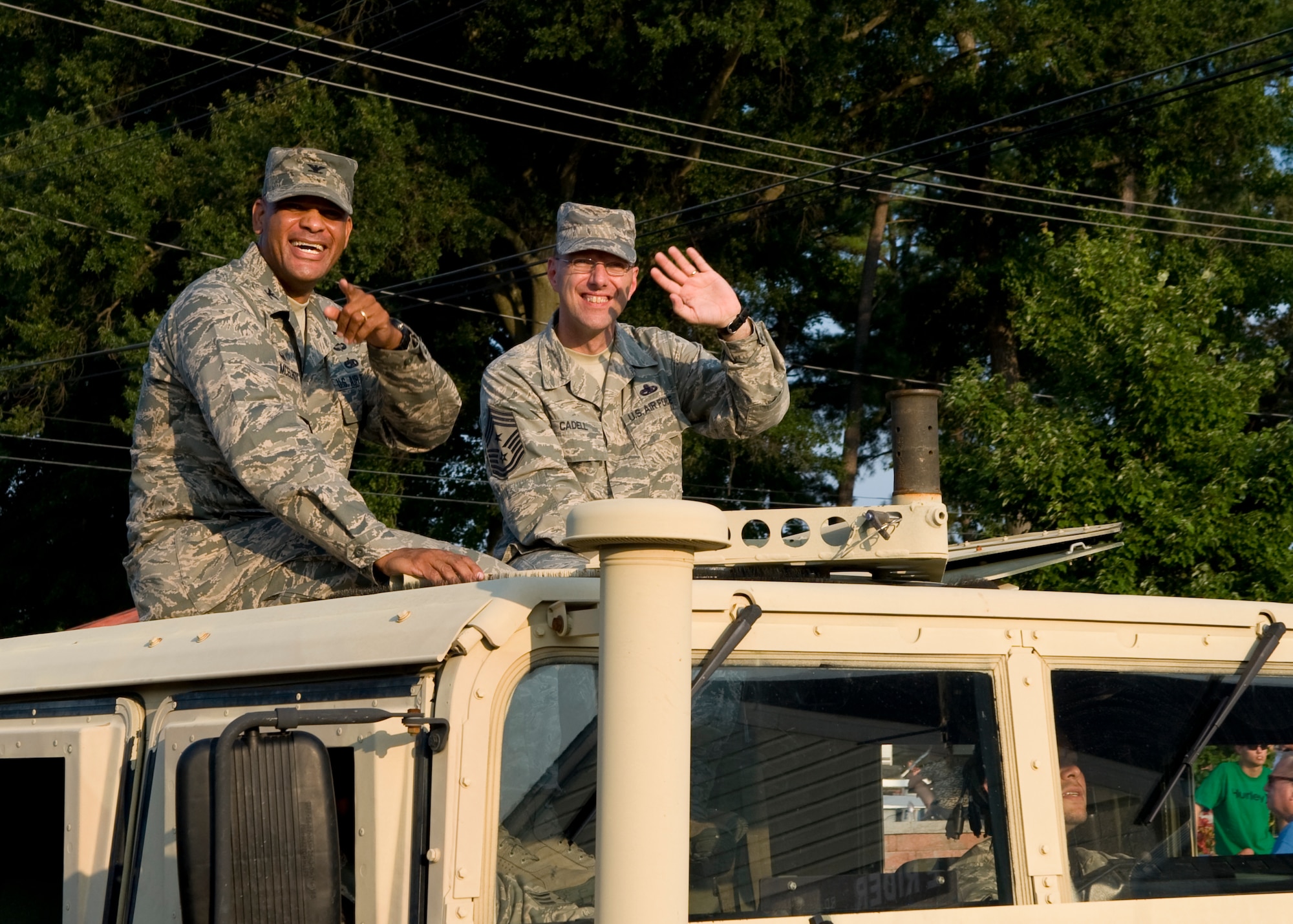 Col. Kelvin McElroy, 512th Maintenance Group commander, left, and Chief Master Sgt. Stanley C. Cadell, 436th Airlift Wing command chief, ride atop a Humvee during a parade at the Delaware State Fair July 23, 2014, at the Delaware State Fairgrounds in Harrington, Del. It is an annual tradition for Team Dover to participate in the fair festivities. (U.S. Air Force photo/Airman 1st Class Zachary Cacicia) 