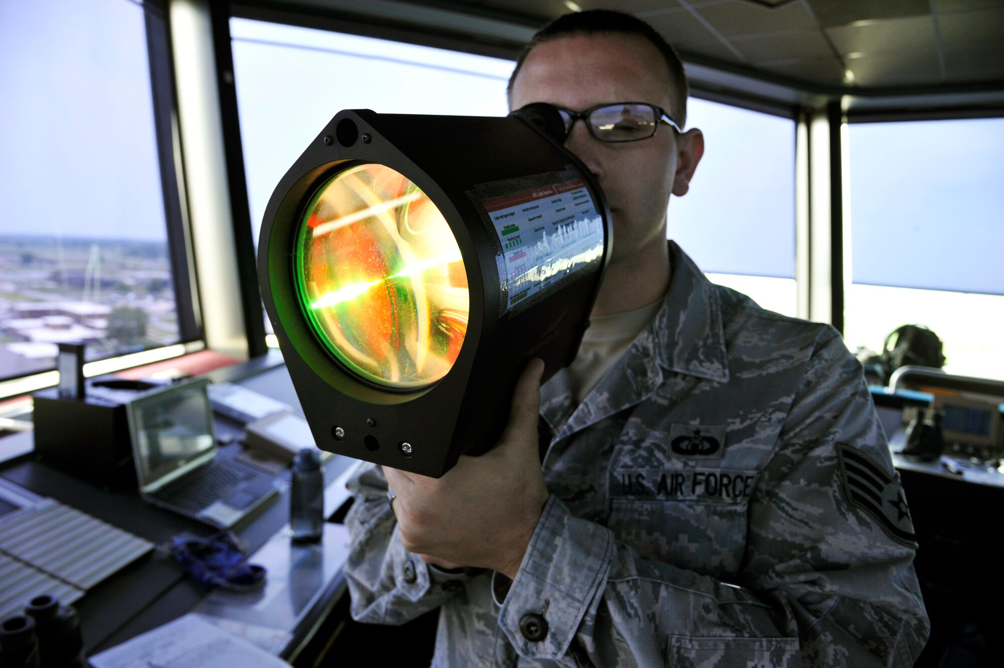 U.S. Air Force Staff Sgt. Joshua Batman,509th Operations Support Squadron air traffic controller, operates a light gun at Whiteman Air Force Base, Mo., July 10, 2014. The light gun is used to communicate safety and movement signals to individuals on the flightline. (U.S. Air Force photo by Airman 1st Class Keenan Berry/Released)