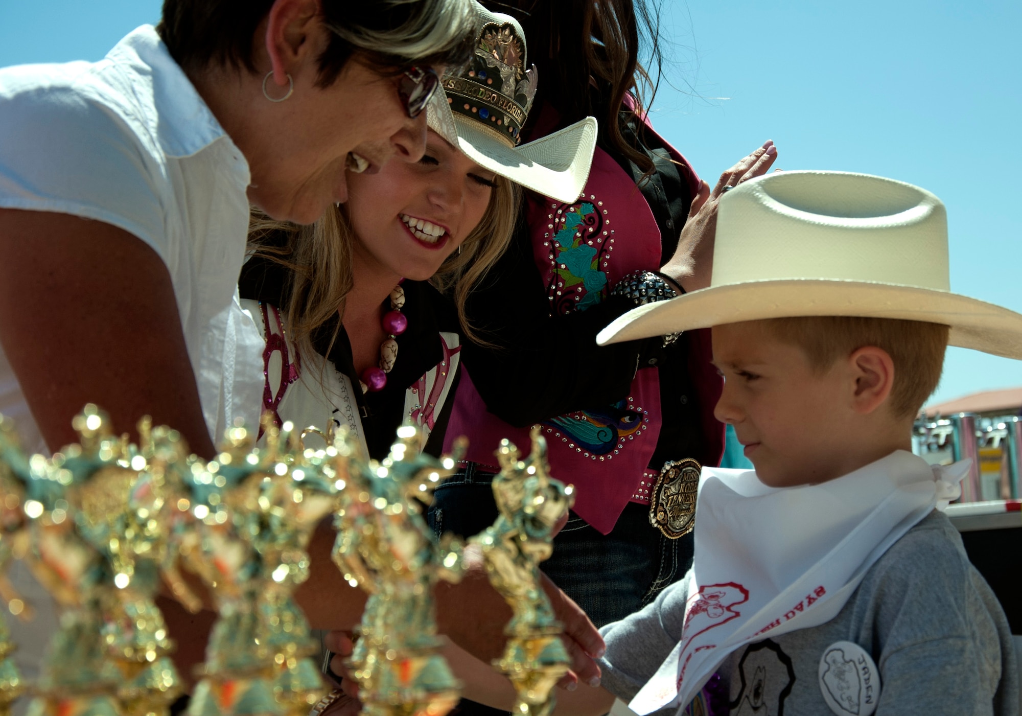 140724-F-GZ967-060 Jaden Kinnison, 6, receives a trophy for participating in the 2014 Cheyenne Frontier Days Challenge Rodeo July 24. Devon Firestone, Miss Rodeo Florida, and Alice Hunter, Laramie County School District 1 director of special services, handed out trophies to every participant in the rodeo. (U.S. Air Force photo by Airman 1st Class Brandon Valle)