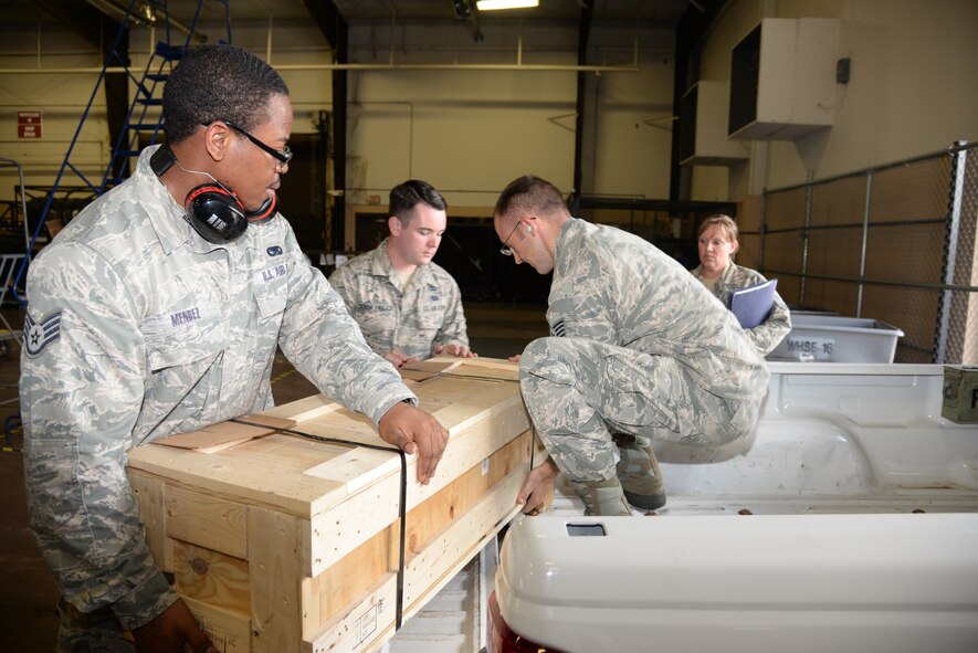 U.S. Air Force Staff Sgts. Kenrick Mendez (left) and Nathan Tabor (middle), 23d Logistics Readiness Squadron aircraft store supervisors, help Tech. Sgt. Christopher McClure, 23d Equipment Maintenance Squadron aerospace ground equipment craftsman, push a piece of support equipment onto a truck bed, July 24, 2014 at Moody Air Force Base, Ga. The 23d LRS part store employees provide 24-hour mission support to Team Moody. (U.S. Air Force photo by Airman 1st Class Marrero/Sandra)
