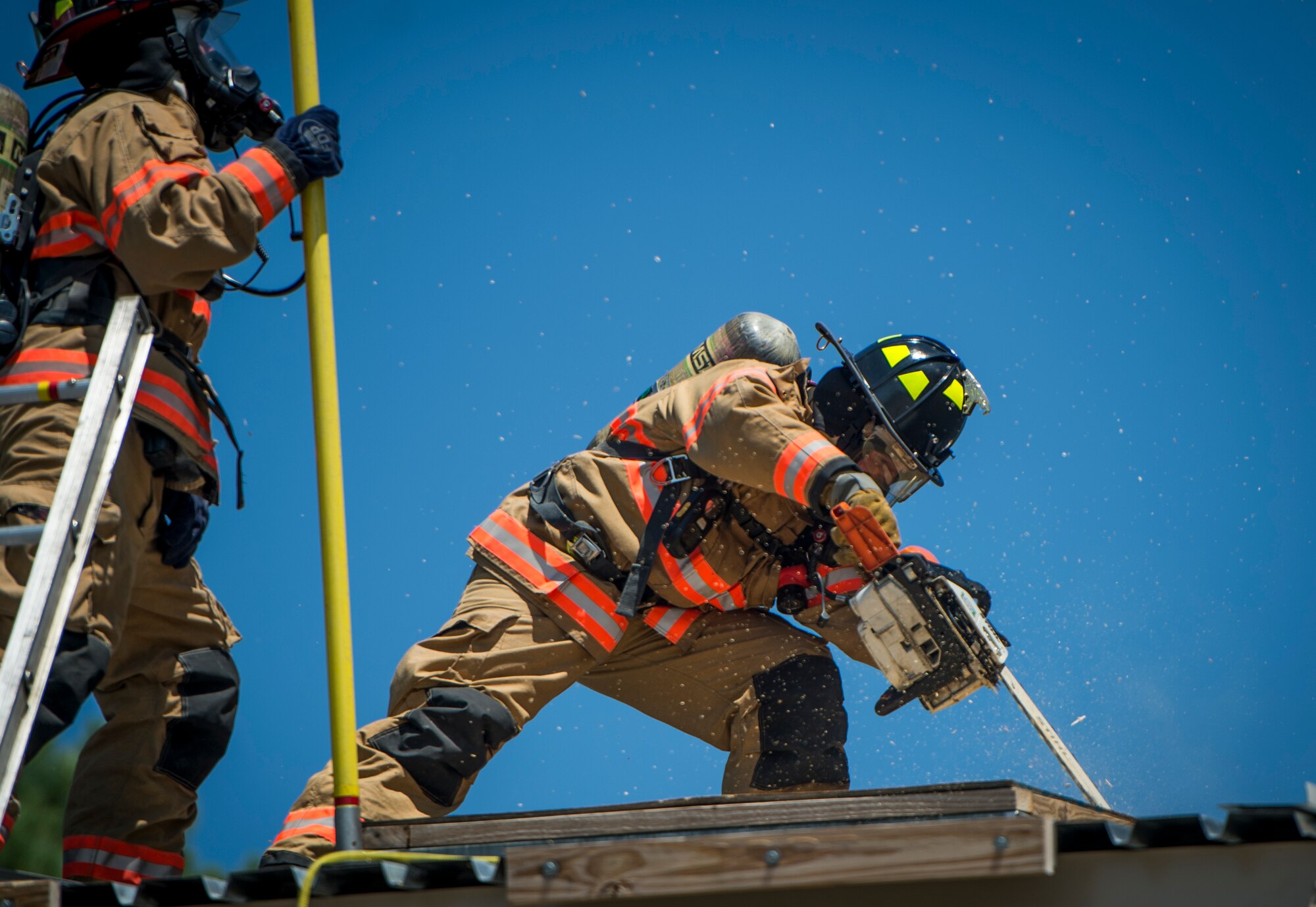 A Hurlburt Field firefighter uses a high-powered saw during training on Hurlburt Field, Fla., July 17, 2014. The saw was used to cut a square into the roof of a simulated smoke-filled building to allow smoke to escape. (U.S. Air Force photo/Senior Airman Christopher Callaway)
