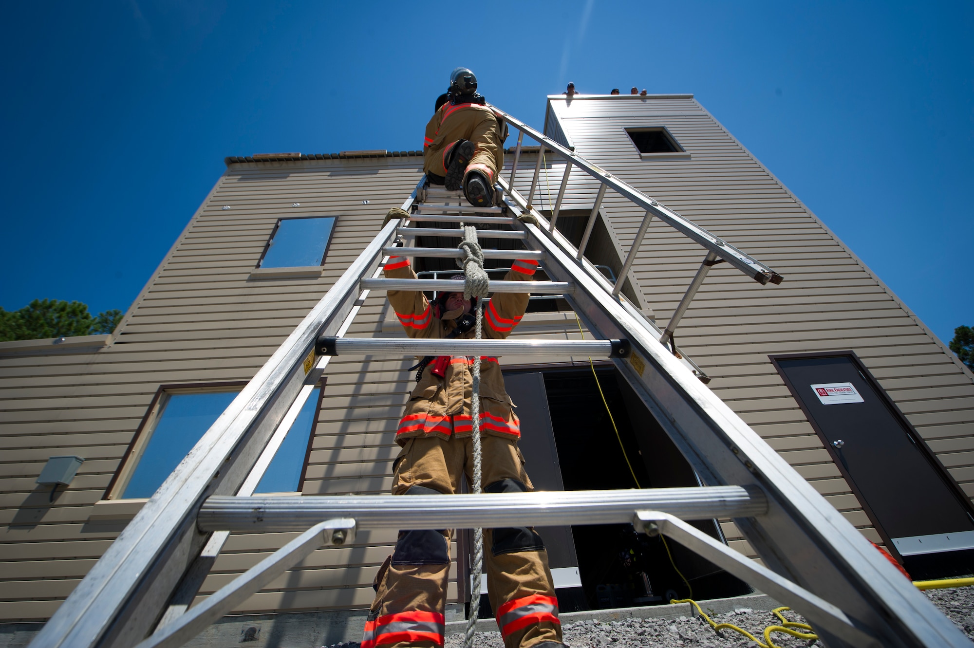 A 1st Special Operations Civil Engineer Squadron firefighter climbs a ladder during training on Hurlburt Field, Fla., July 17, 2014. Firefighters spent more than an hour training on the proper technique to vent a smoke-filled building. (U.S. Air Force photo/Senior Airman Christopher Callaway) 