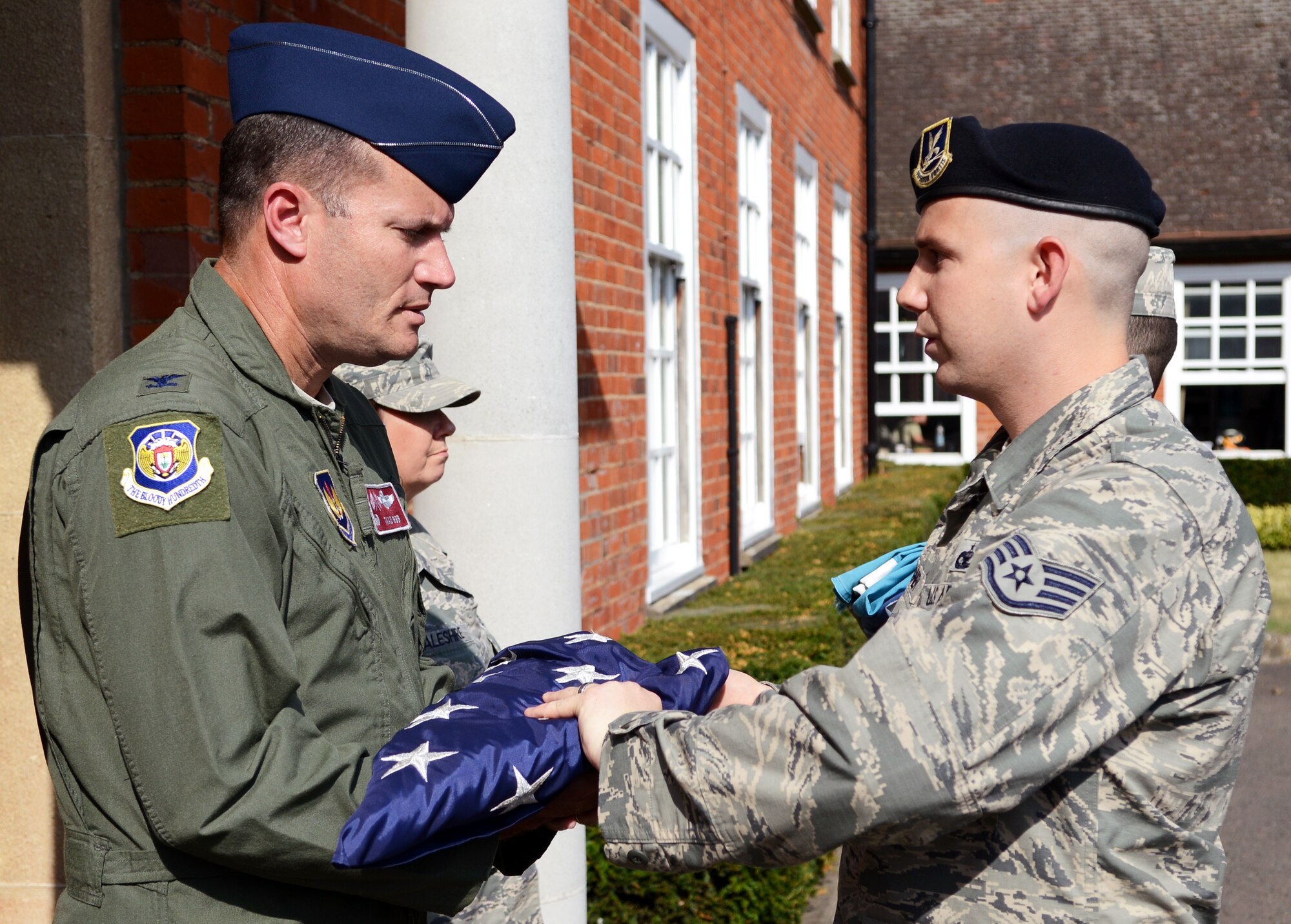 U.S. Air Force Col. Kenneth T. Bibb Jr., left, 100th Air Refueling Wing commander, receives the U.S. flag from a flag detail after a retreat ceremony July 25, 2014, on RAF Mildenhall, England. Retreat is a long-standing tradition honoring the U.S. flag at the end of the duty day. (U.S. Air Force photo/Airman 1st Class Dillon Johnston/Released)