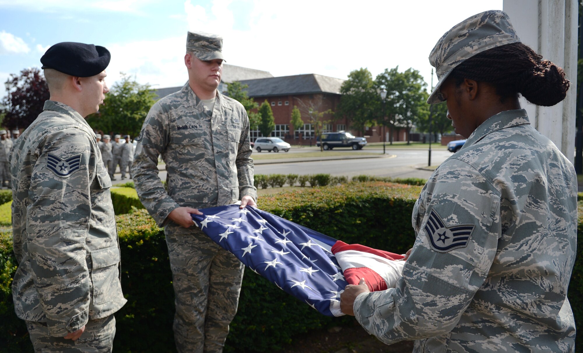 Members of a Team Mildenhall flag detail fold the U.S. flag during a retreat ceremony July 25, 2014, on RAF Mildenhall, England. In the time-honored tradition of the retreat ceremony, the U.S. flag and Royal Air Force ensign are folded to signify the end of the duty day. (U.S. Air Force photo/Airman 1st Class Dillon Johnston/Released) 