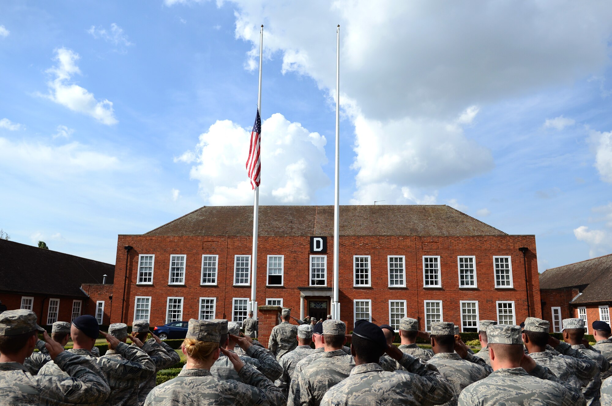 Members of Team Mildenhall salute the U.S. flag as it’s lowered during the monthly retreat ceremony July 25, 2014, on RAF Mildenhall, England. Airmen from the 100th Mission Support Group paid their respects to the U.S. flag and Royal Air Force ensign during the ceremony. (U.S. Air Force photo/Airman 1st Class Dillon Johnston/Released)