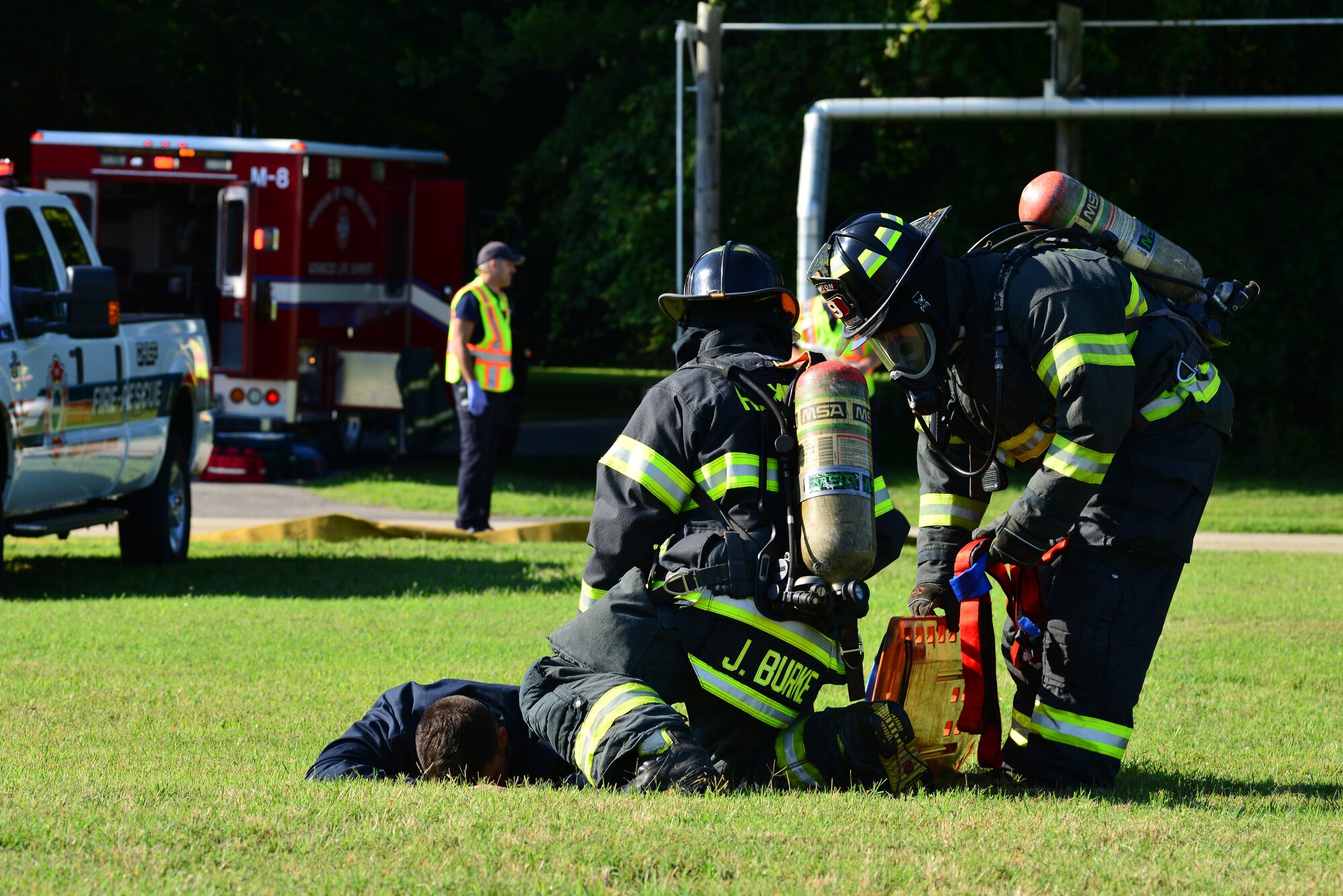 Firefighters from the NASA-Langley Research Center prepare to transport a simulated deceased pilot during an exercise at Langley Air Force Base, Va., July 25, 2014. The research center, Langley Air Force Base and City of Hampton firefighters responded to a mock aircraft accident, and were evaluated on their recovery actions. (U.S. Air Force photo by Senior Airman Aubrey White/Released)