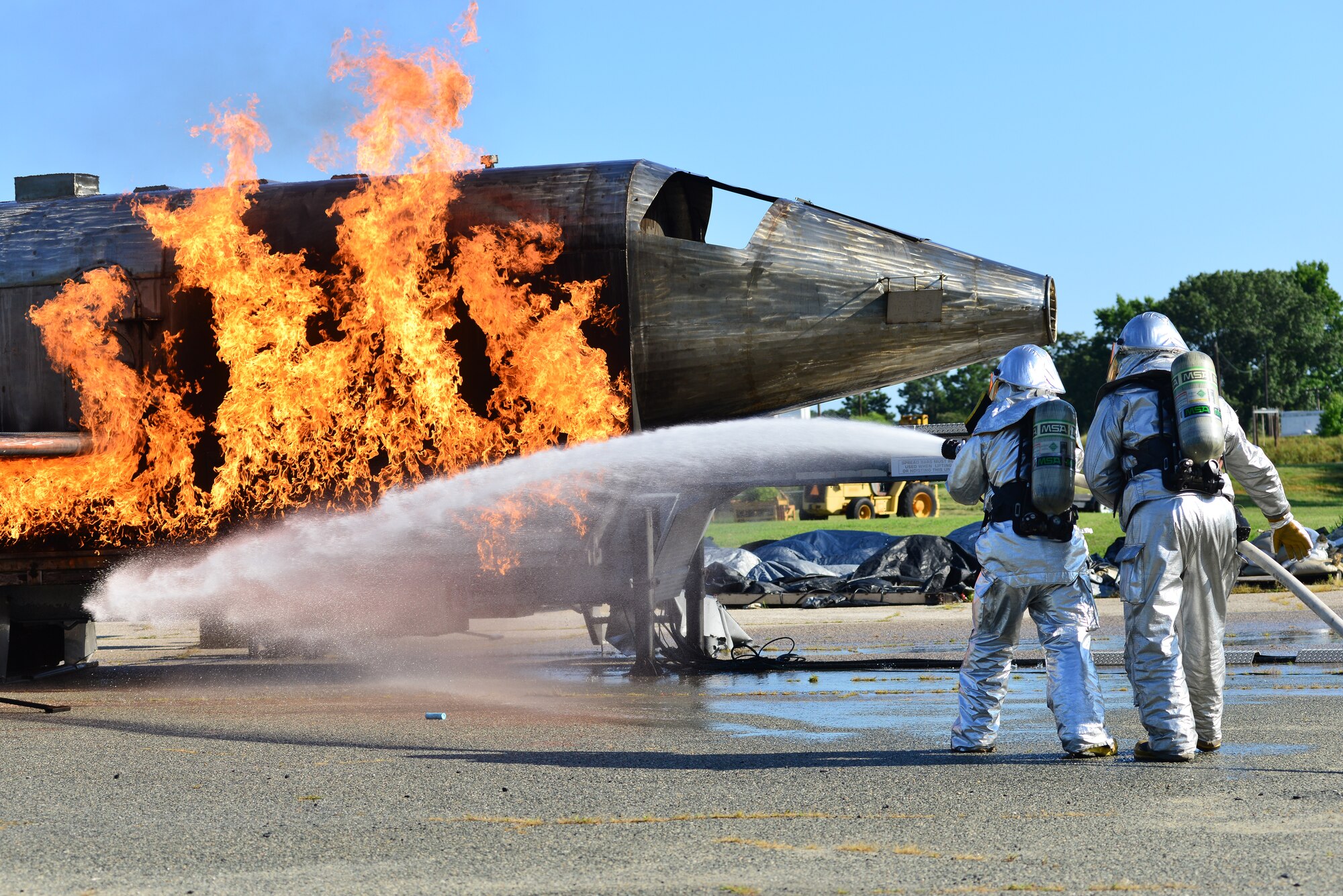 Firefighters from the 633rd Civil Engineer Squadron extinguish a simulated aircraft fire during an exercise at Langley Air Force Base, Va., July 25, 2014. Langley Air Force Base, NASA-Langley Research Center and City of Hampton, Va., emergency services were tested on their ability to effectively respond to an F-22 Raptor crash. (U.S. Air Force photo by Senior Airman Aubrey White/Released) 