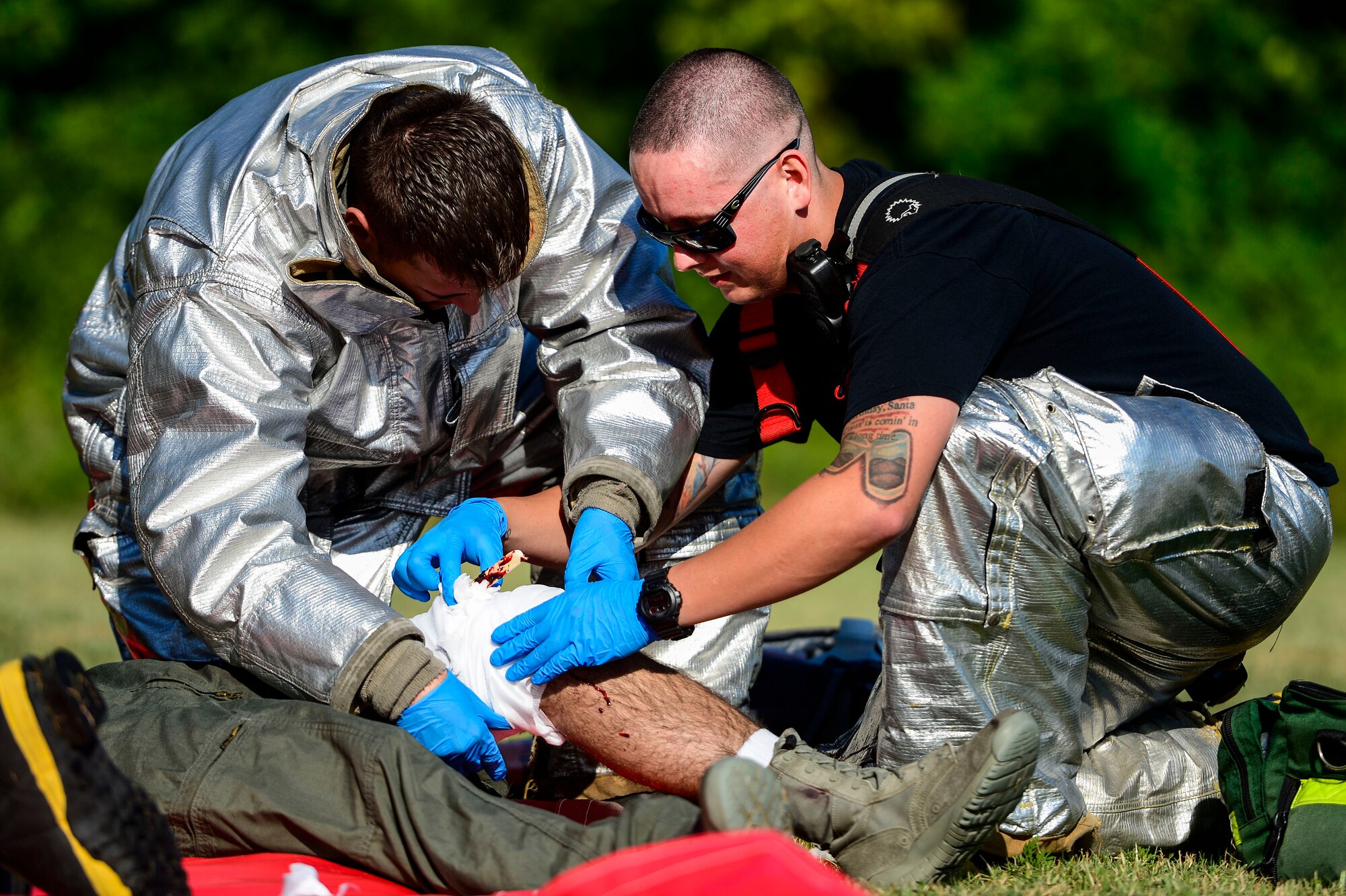 U.S. Air Force Staff Sergeant’s Geoffrey Range and Tylor Ketring, 633rd Civil Engineer Squadron firefighters, assist a simulated injured pilot during an exercise at Langley Air Force Base, Va., July 25, 2014. The City of Hampton and Langley emergency responders were evaluated on their ability to respond to an off-base aircraft crash that included simulated injuries and casualties. (U.S. Air Force photo by Senior Airman Kayla Newman/Released)  