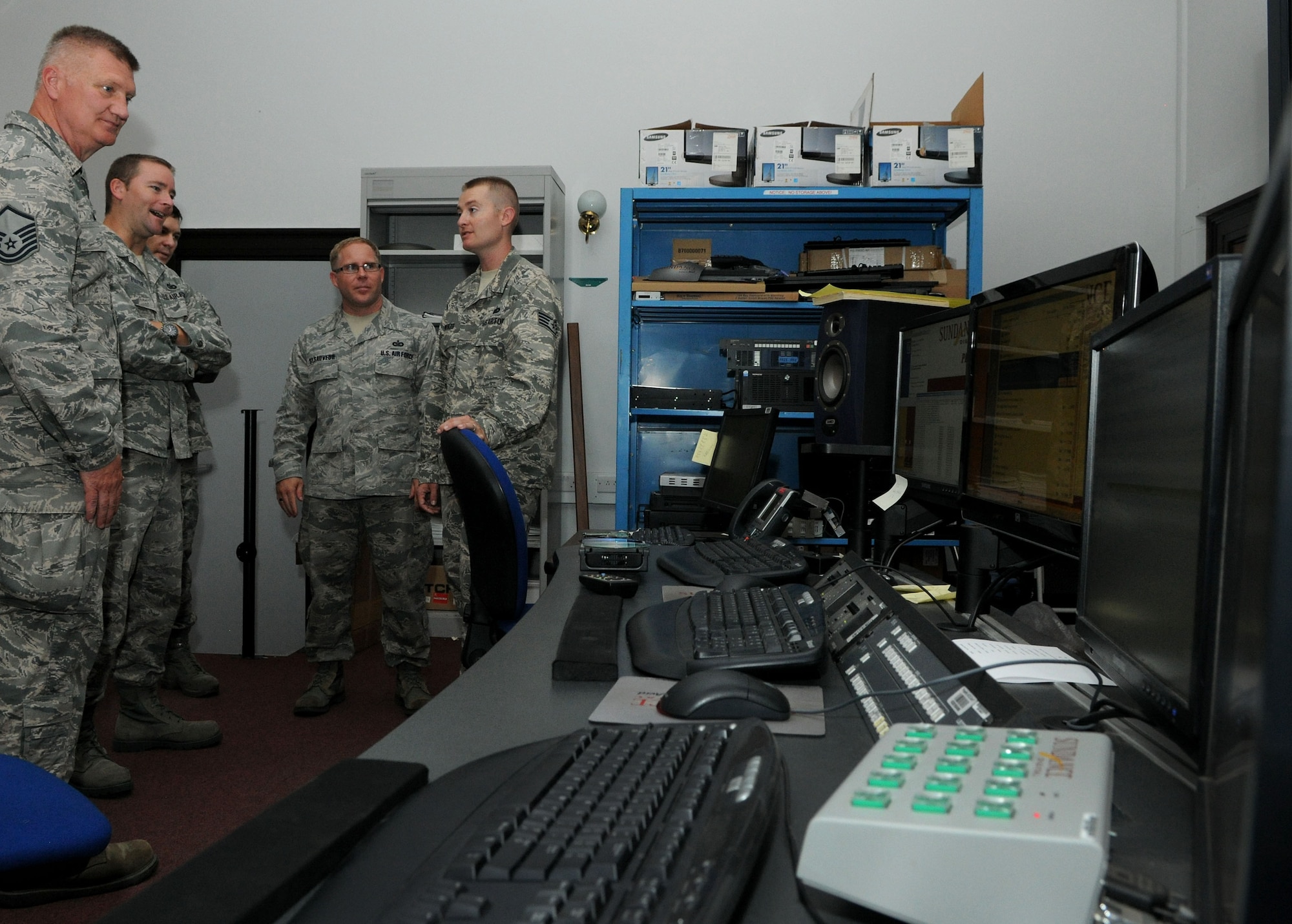 Broadcast journalists from American Forces Network-United Kingdom show Oklahoma Air National Guard Public Affairs Airmen from Altus Air Force Base, Okla., AFN-UK’s automation room during a tour July 23, 2014, on RAF Feltwell, England. The automation room is where AFN Airmen program their spots and upload AFN schedules so the local area may continue to receive their service. (U.S. Air Force photo/Senior Airman Kate Maurer/Released)