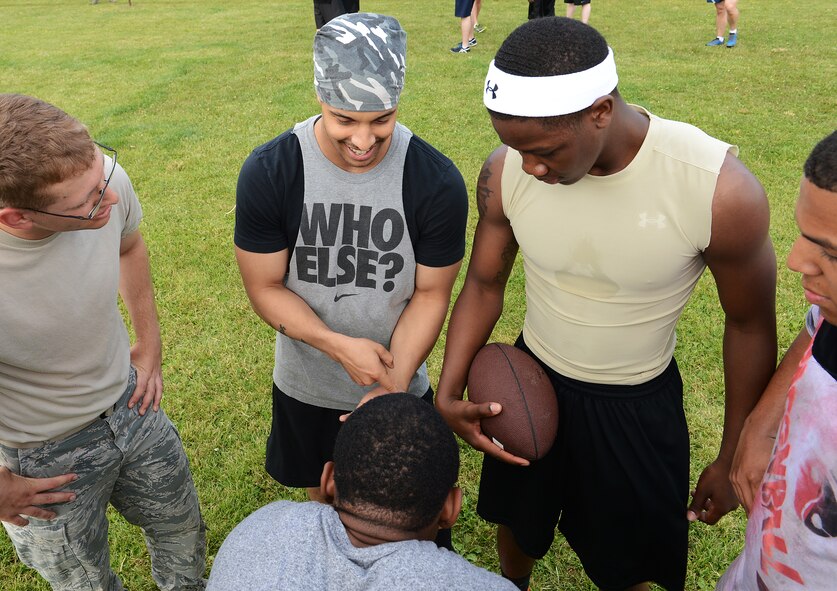 People gather to play football during Resiliency Day on June 19, 2014 at Ramstein Air Base, Germany. The day allowed the members of the 86th Airlift Wing to get out and meet new people as well as build teams and working relationships. (U.S. Air Force photo/Airman 1st Class Michael Stuart)