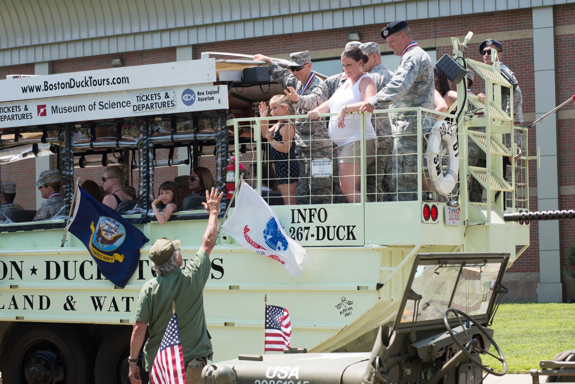 Recent deployers wave during the Hanscom Homecoming parade at Hanscom Air Force Base, Mass., July 23. More than 70 Airmen who have returned home from deployment in the past year, along with their family members, were honored during this summer's Heroes Homecoming. (U.S Air Force photo by Mark Herlihy)