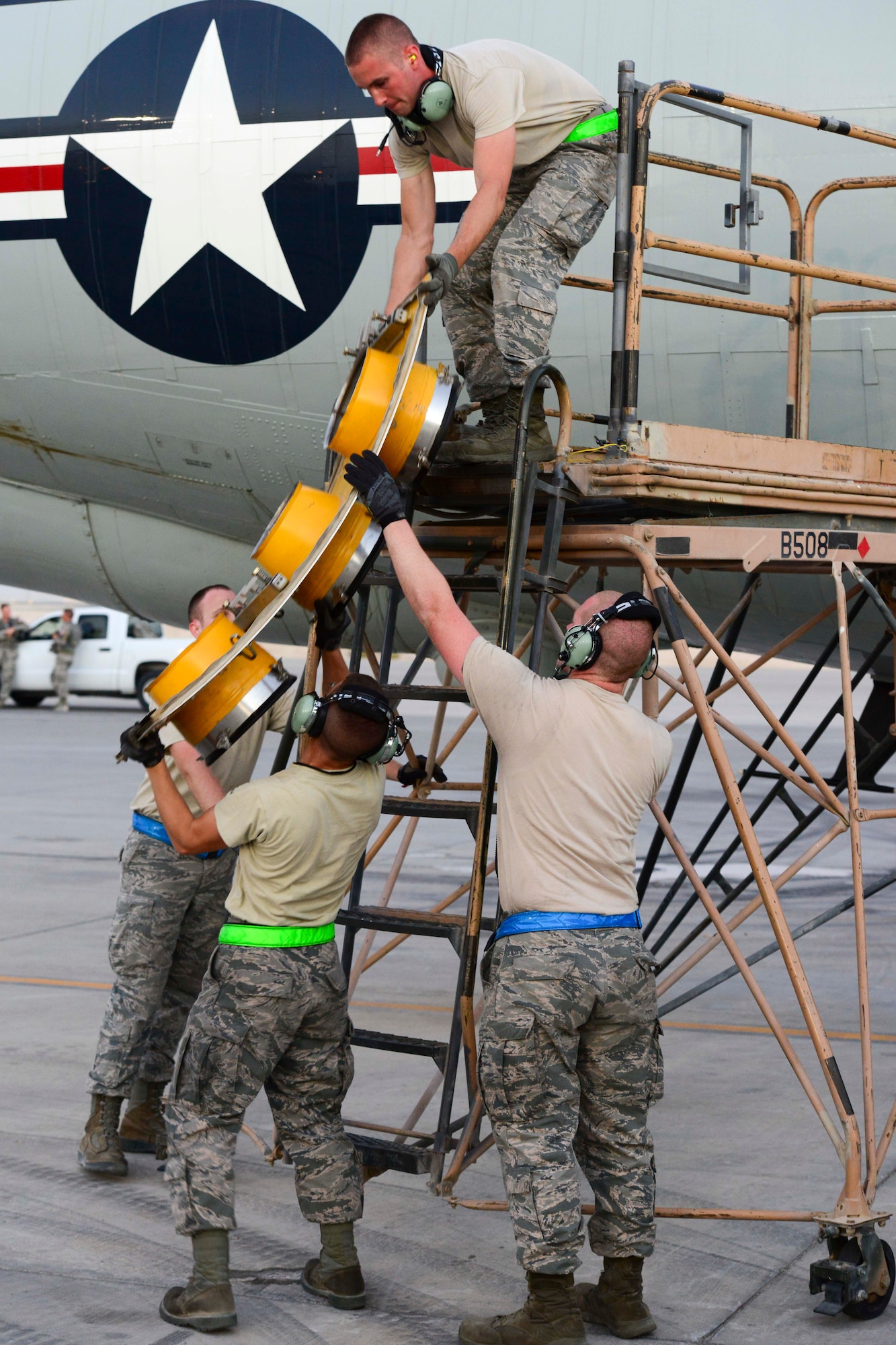 U.S. Air Force Airmen assigned to the 763rd Aircraft Maintenance Unit remove an air hatch adapter from a RC-135 Rivet Joint at Al Udeid Air Base, Qatar, July 11, 2014. The RC-135 provides reconnaisance information and electronic warfare support to theater commanders and combat forces. (U.S. Air Force photo by Staff Sgt. Ciara Wymbs) 