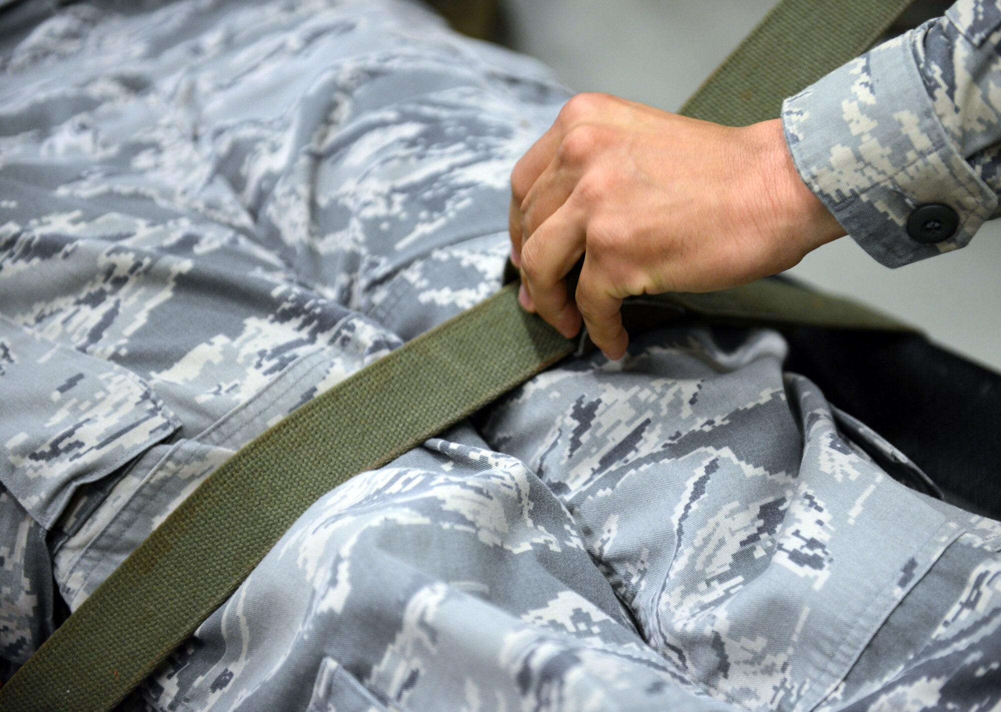 An Airman from the 86th Medical Group secures a strap on a litter during a self-aid and buddy care rodeo at Ramstein Air Base, Germany, July 10, 2014. Members of the 86th Medical Group attended the refresher course to sharpen potentially life-saving techniques taught in SABC. (U.S. Air Force photo/Senior Airman Timothy Moore)