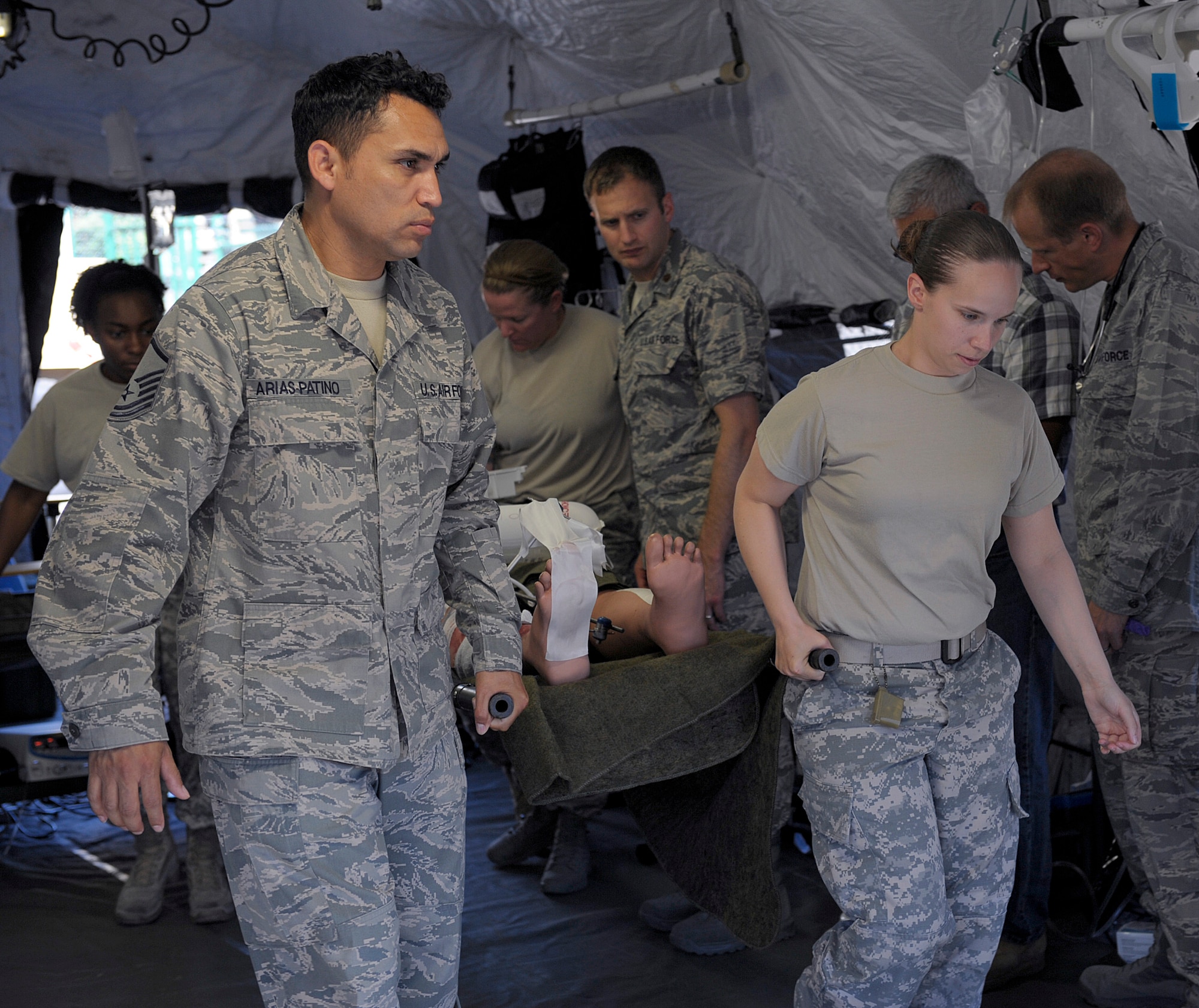 Members of the 86th Medical Group tactical critical care evacuation team-enhanced and the 160th Forward Surgical team carry a training dummy to a simulated medical evacuation zone during joint FST training at Ramstein Air Base, Germany, July 18, 2014. Members of the 86th MDG TCCET-E and the 160th FST trained together to increase their interoperability. (U.S. Air Force photo/Senior Airman Timothy Moore)